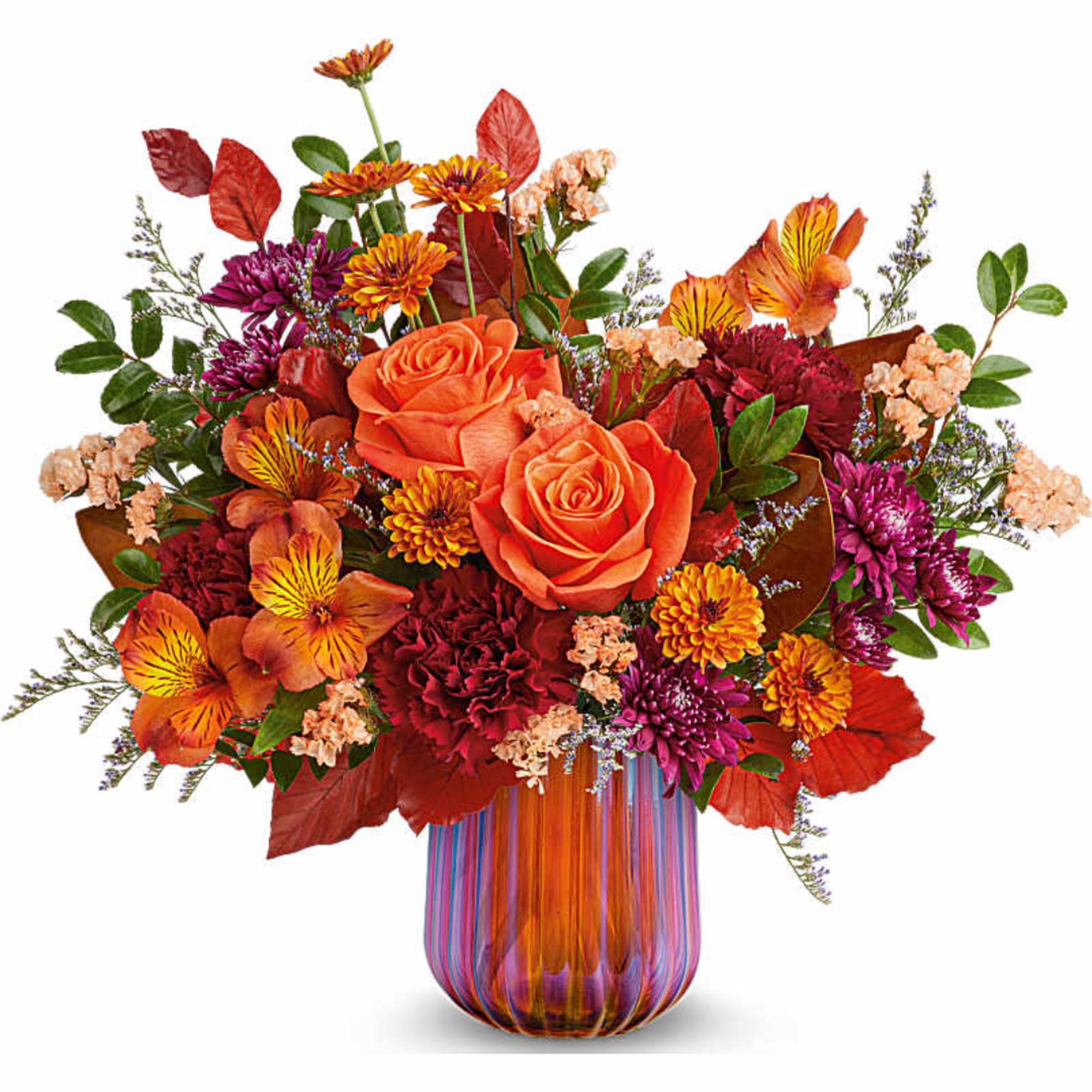 Orange roses and mixed fall flowers in a striped glass vase