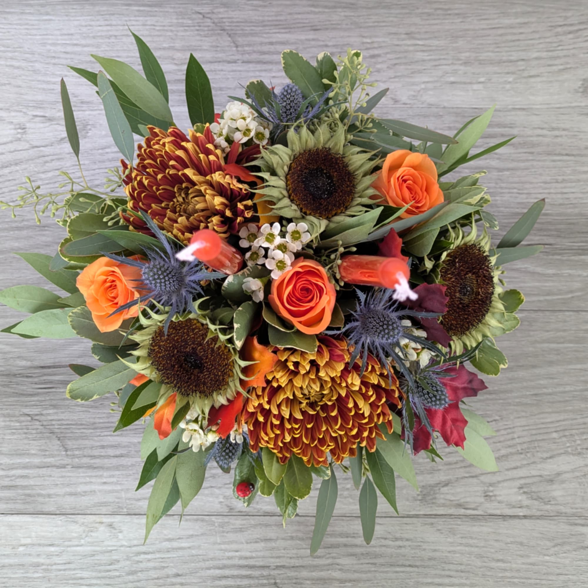 Bouquet with orange roses, sunflowers, and burgundy chrysanthemums