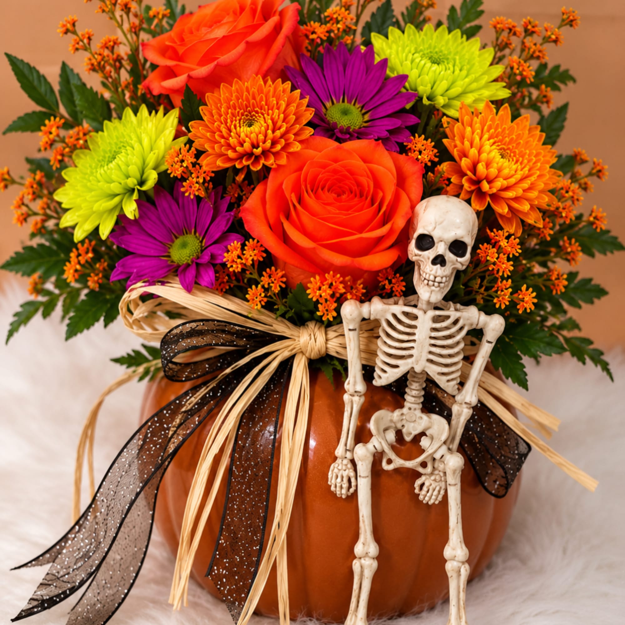 Halloween bouquet in a pumpkin vase with a small skeleton decoration