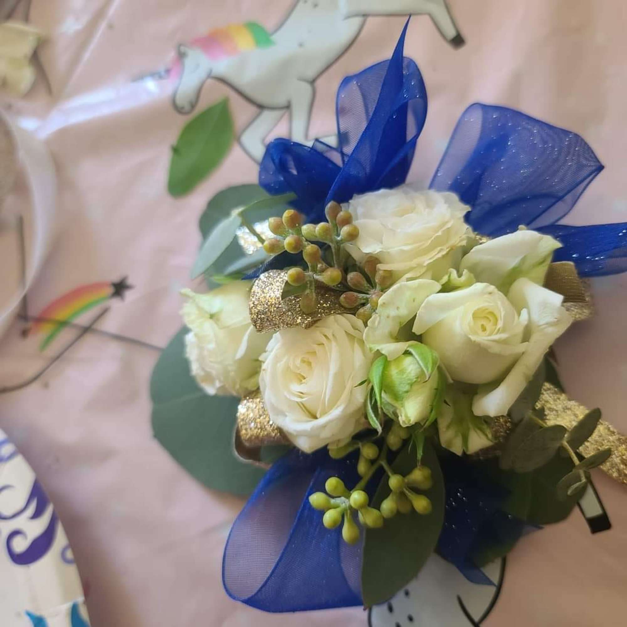 White rose bouquet with blue ribbon and gold accents