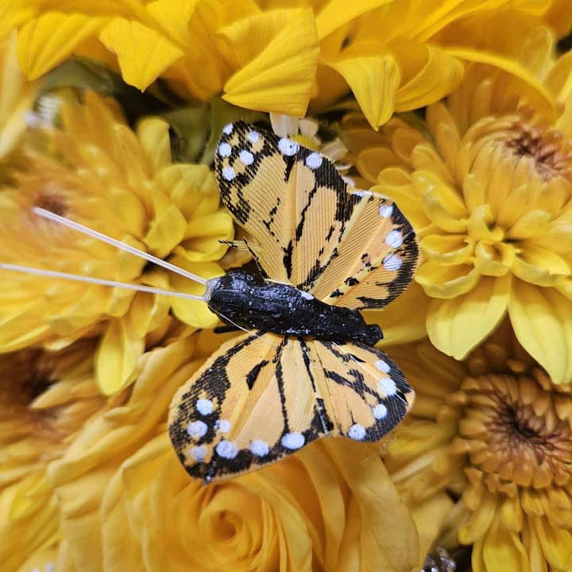 Yellow flower bouquet with a decorative butterfly pick