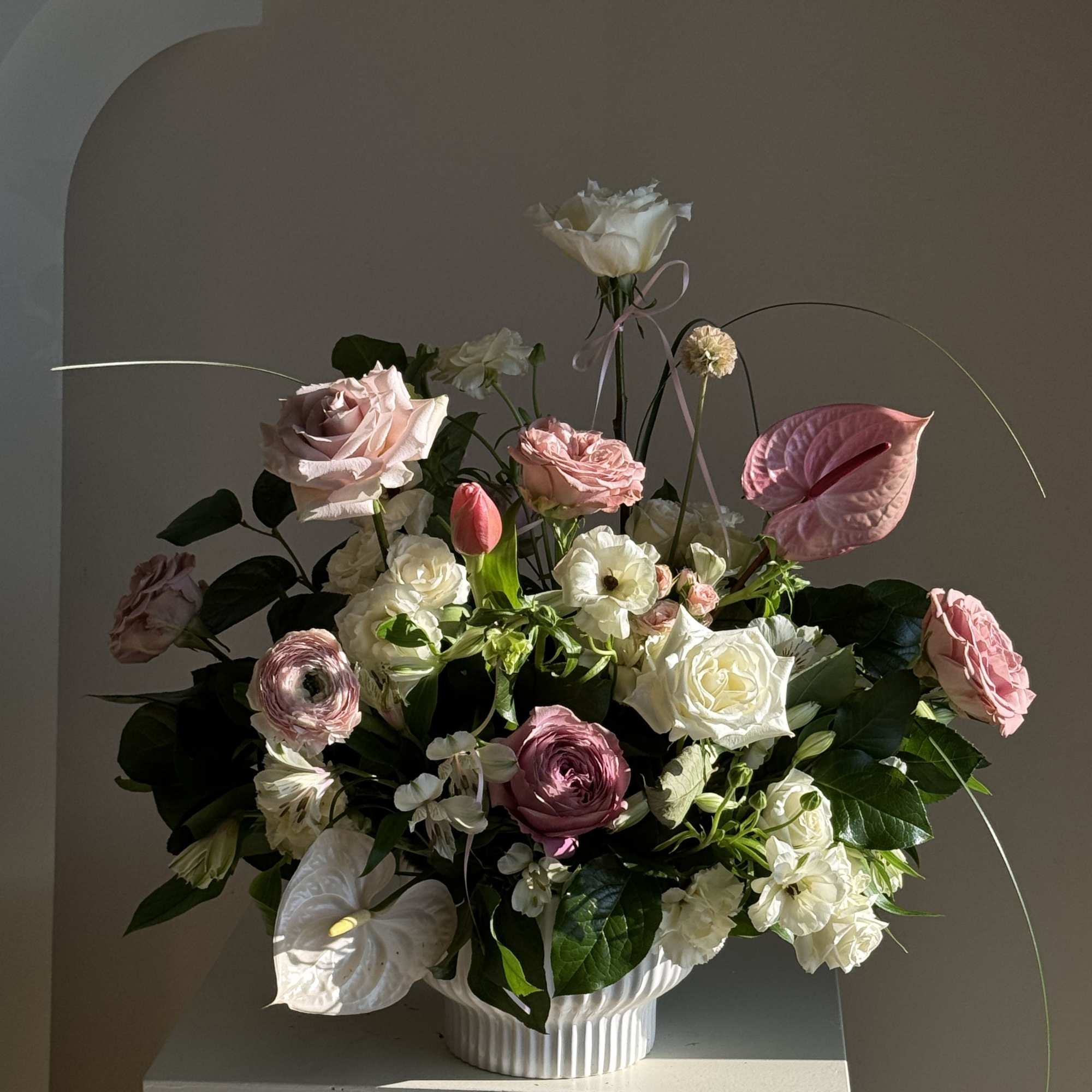 Pink and white floral arrangement in a white vase