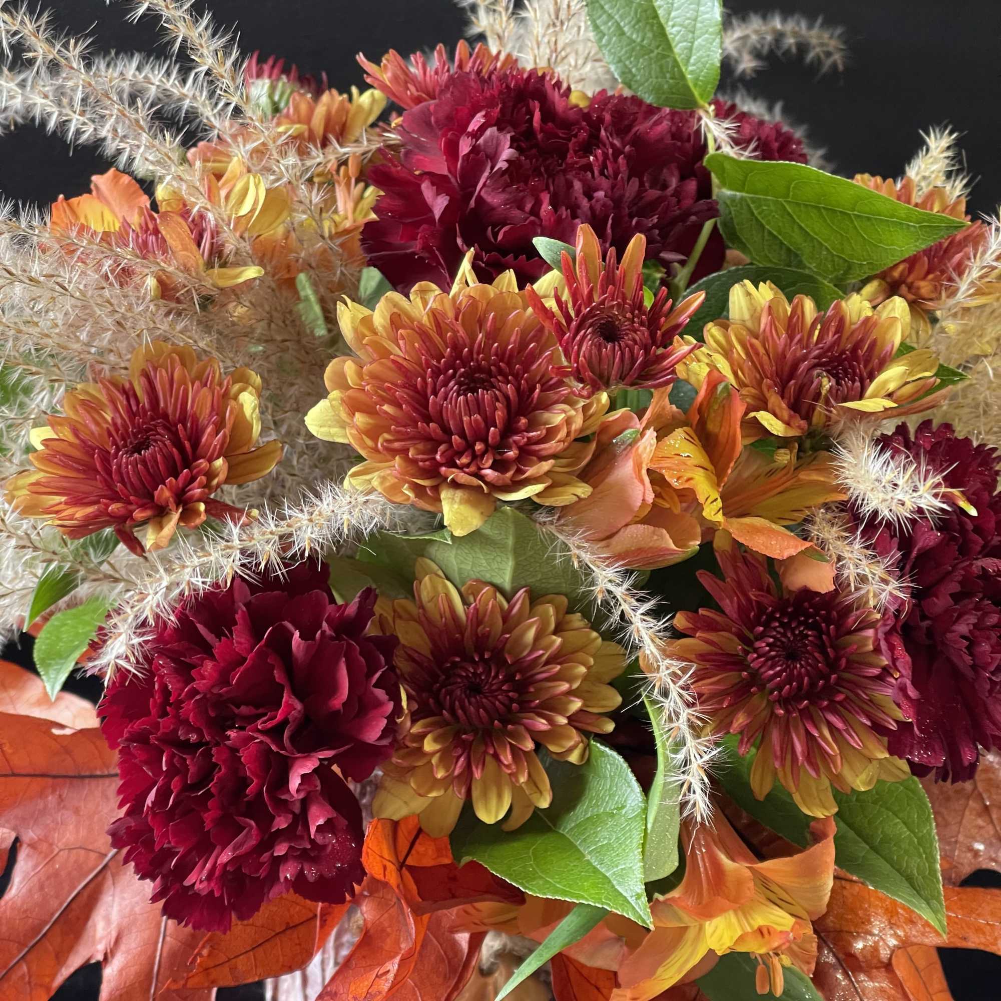 An arrangement that feels like a cozy fall day with fall leaves, photo 2 of 2