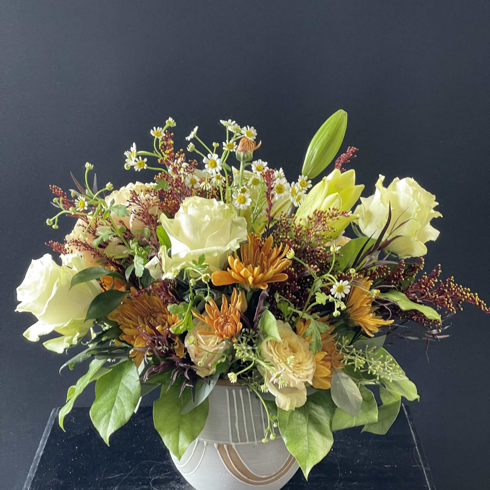 Cream and orange mixed bouquet in a white vase