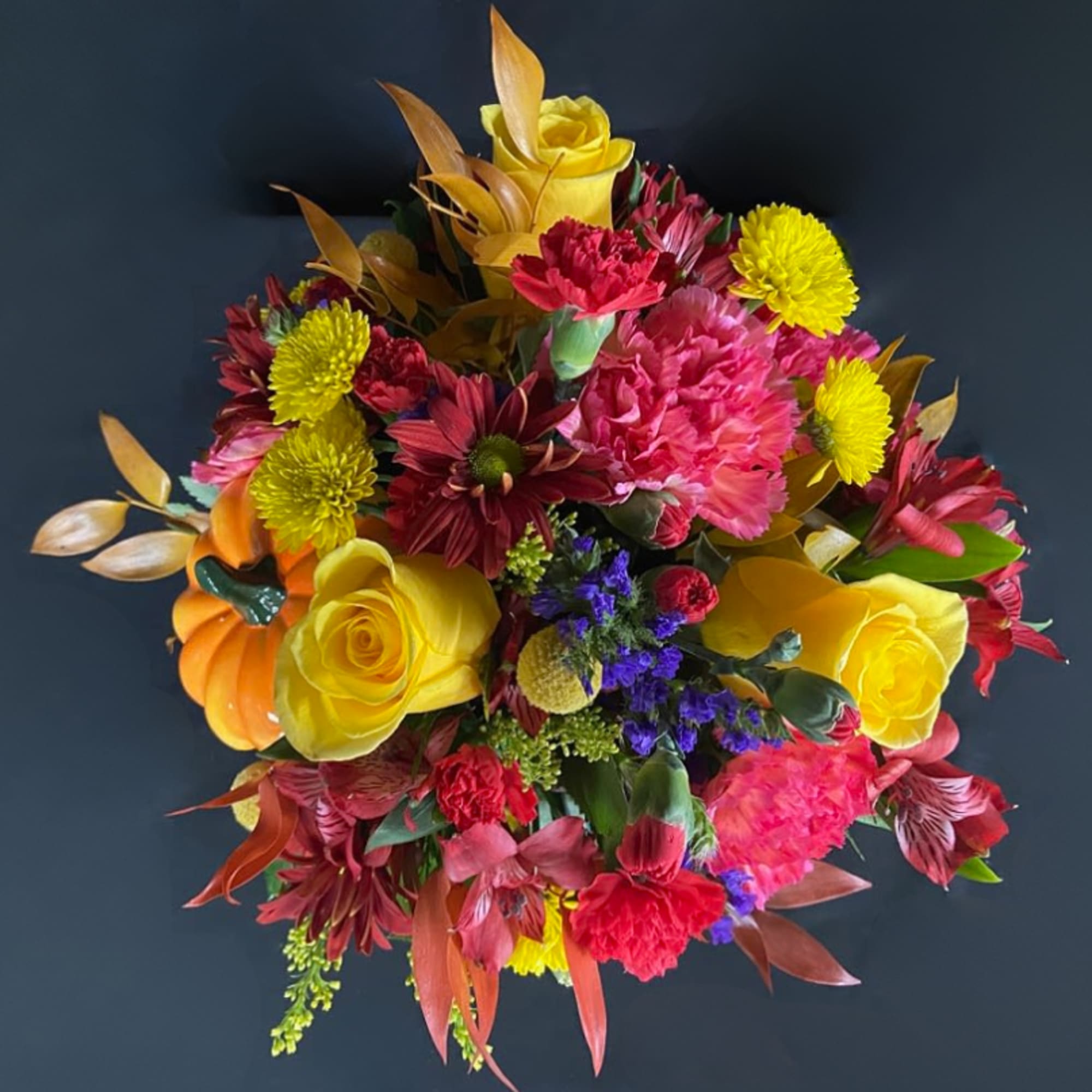 Bright mixed bouquet with yellow roses, pink carnations, and red daisies