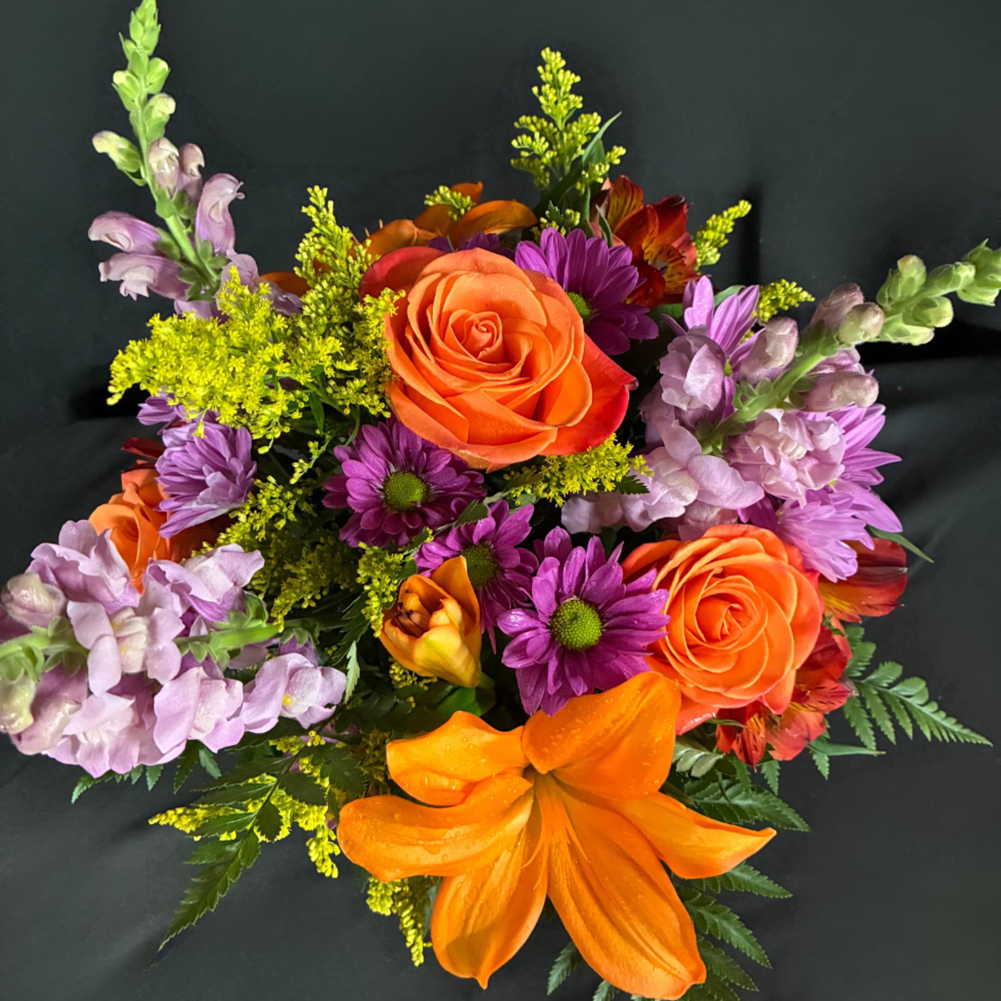 Colorful bouquet with orange roses, purple daisies, and snapdragons