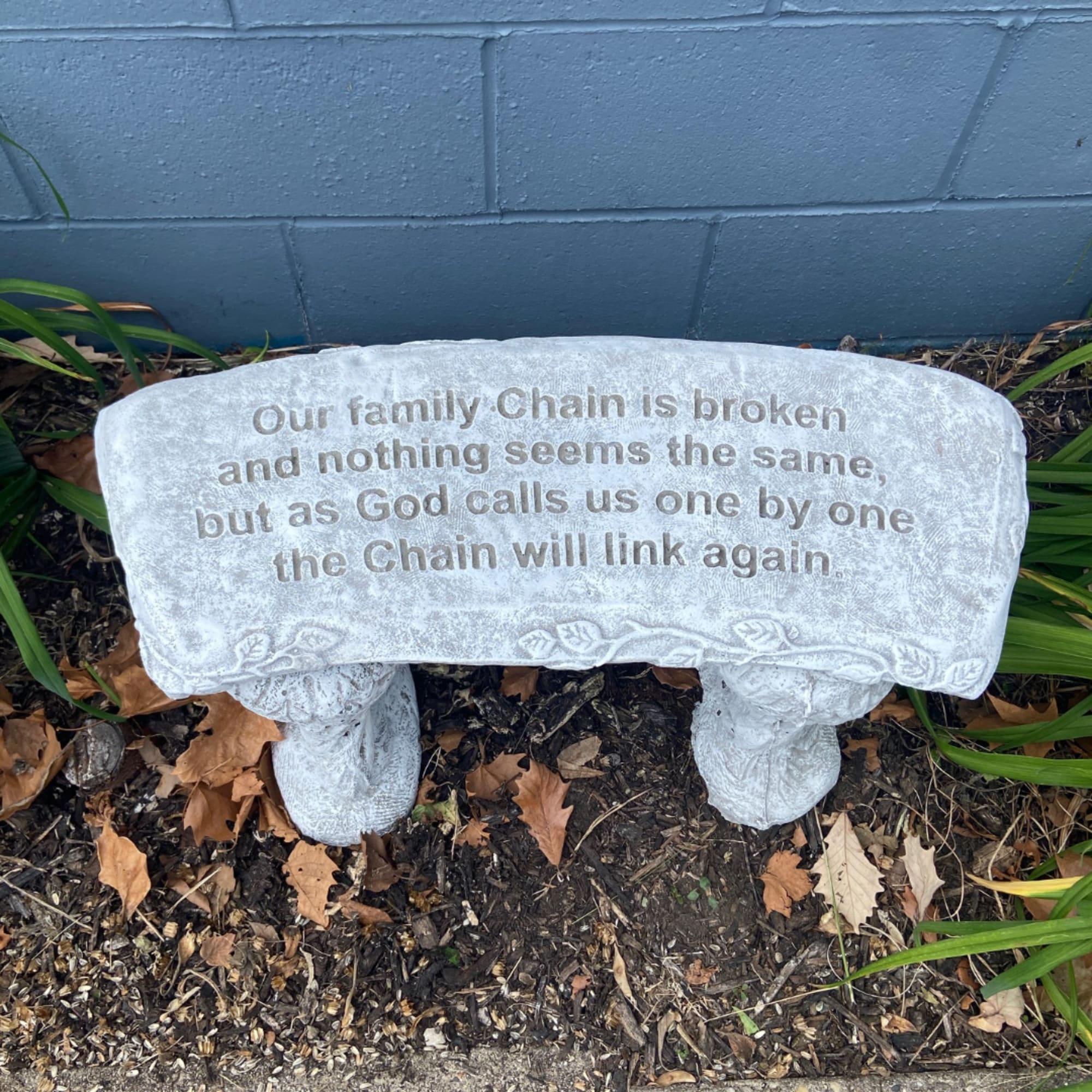 Stone memorial bench with an engraved sympathy message outdoors
