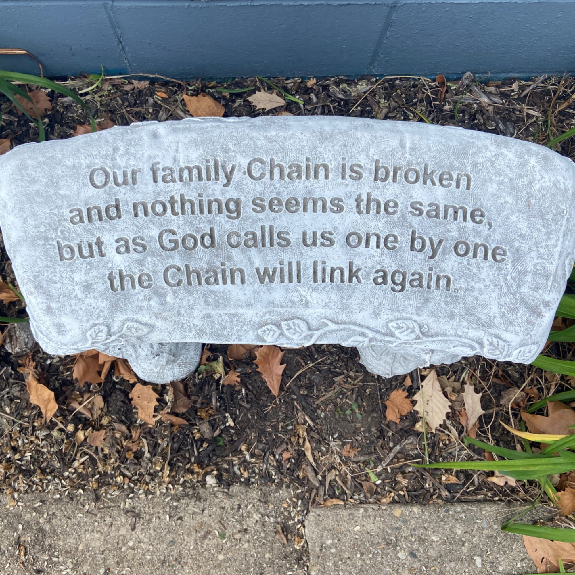 Memorial stone with engraved family-chain message outdoors