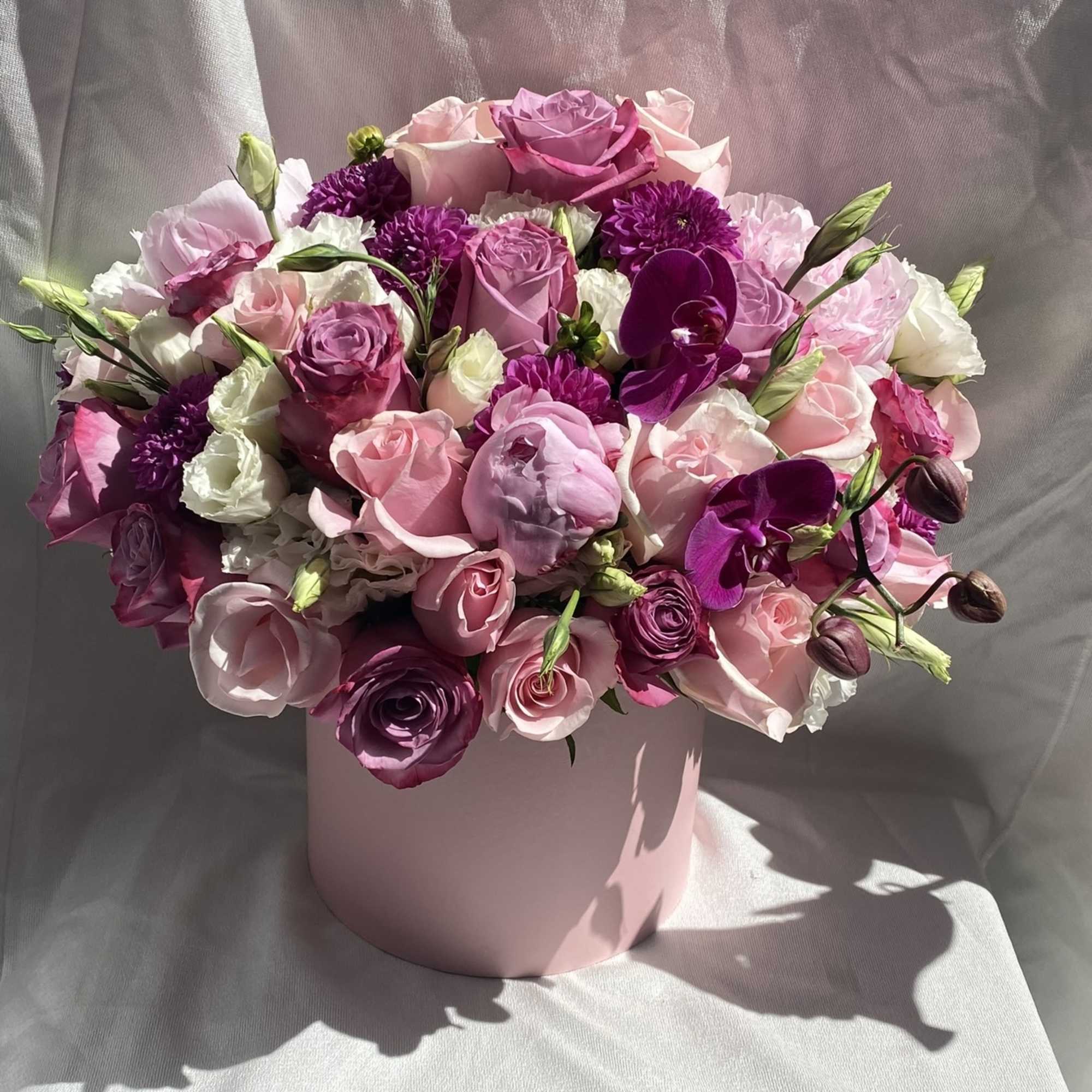 Pink and purple bouquet in a round pink box