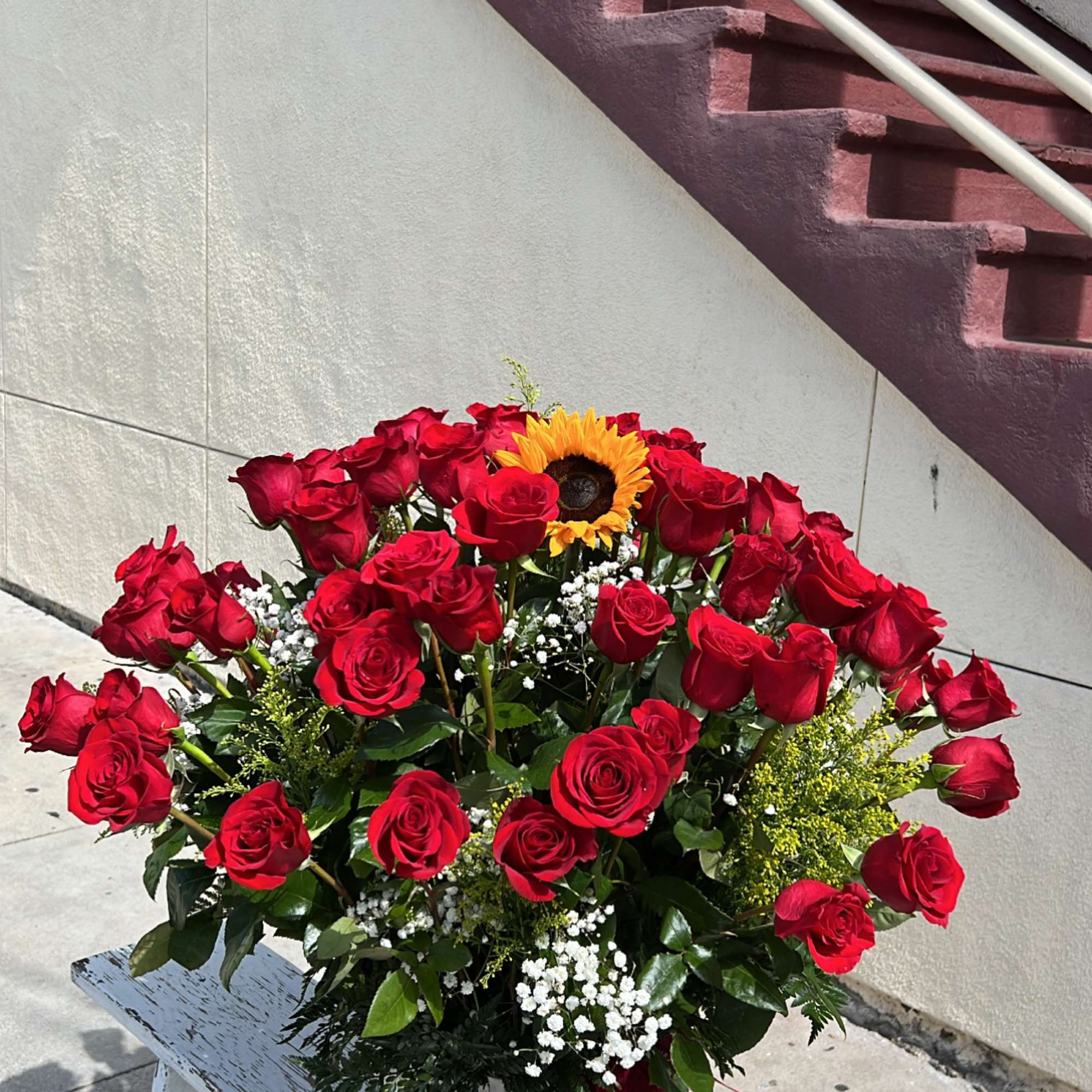 Large bouquet of red roses with a sunflower in a white vase, photo 2 of 3