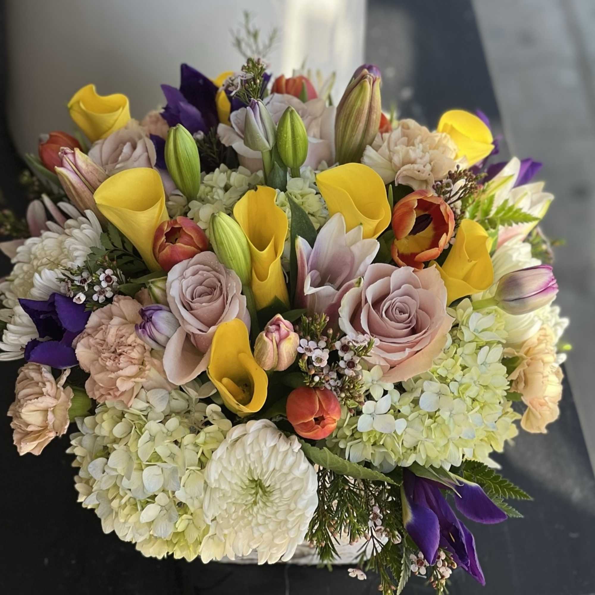 Mixed bouquet with yellow calla lilies, pale roses, and hydrangeas