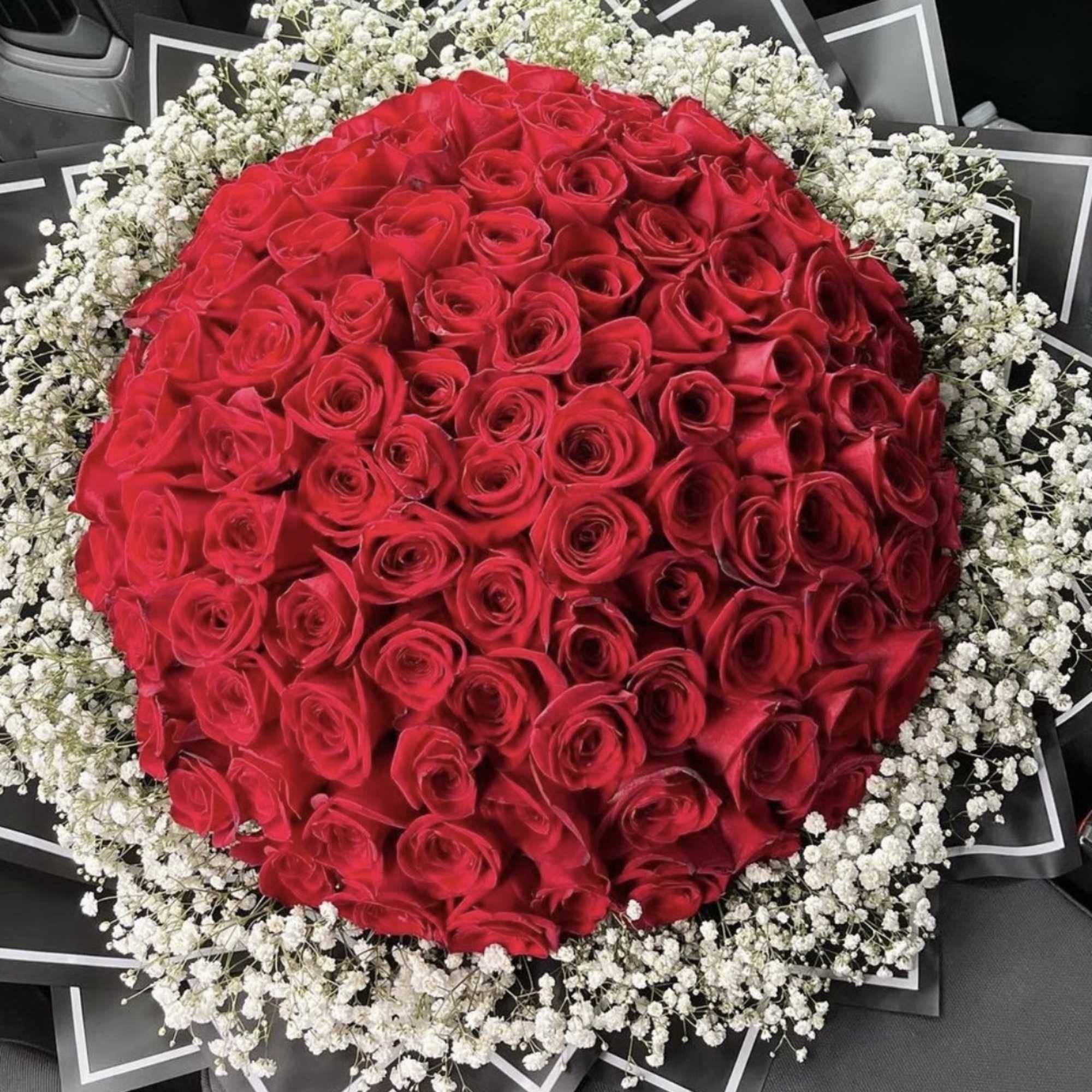 Large round bouquet of red roses with white baby's breath