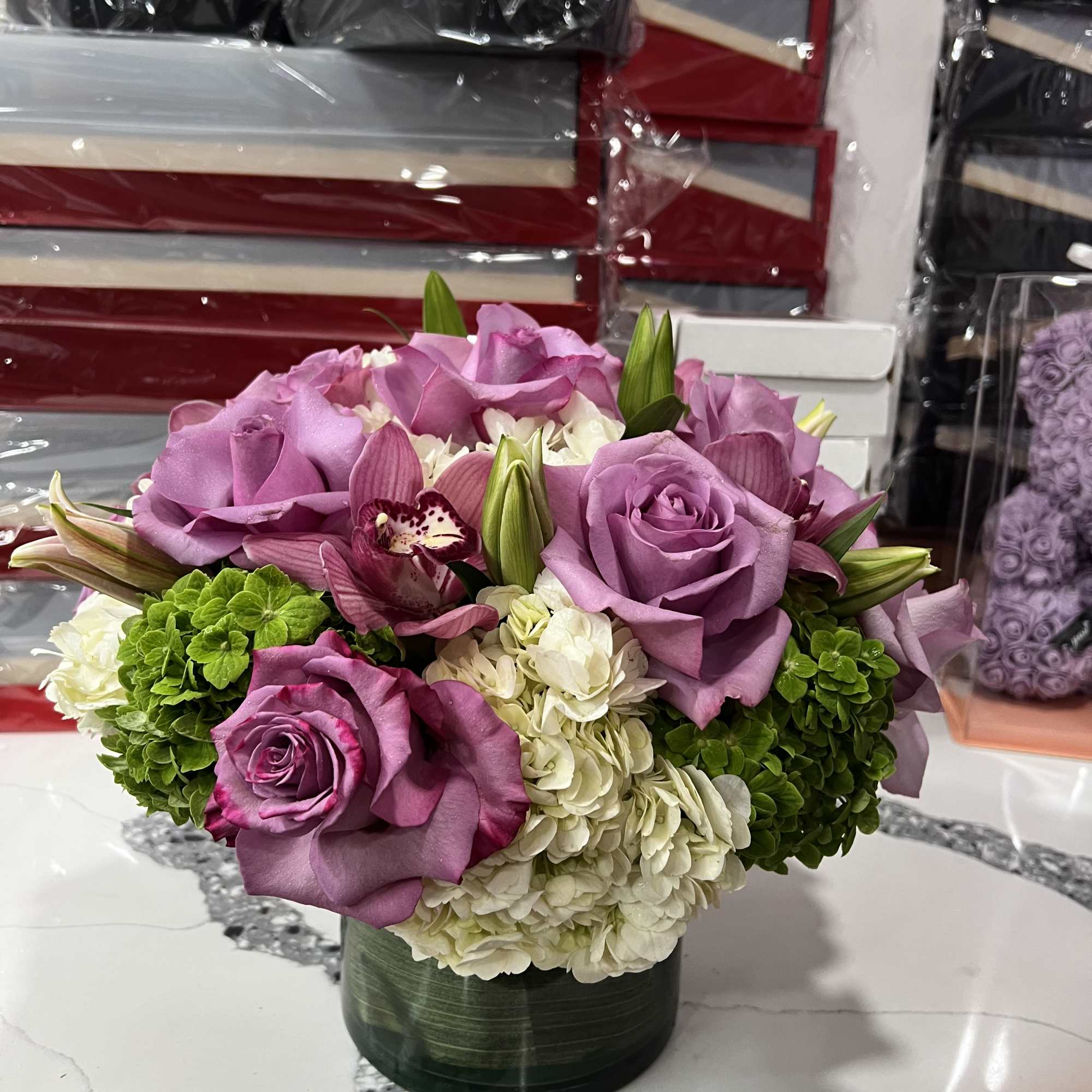 Purple roses and white hydrangeas arranged in a low vase
