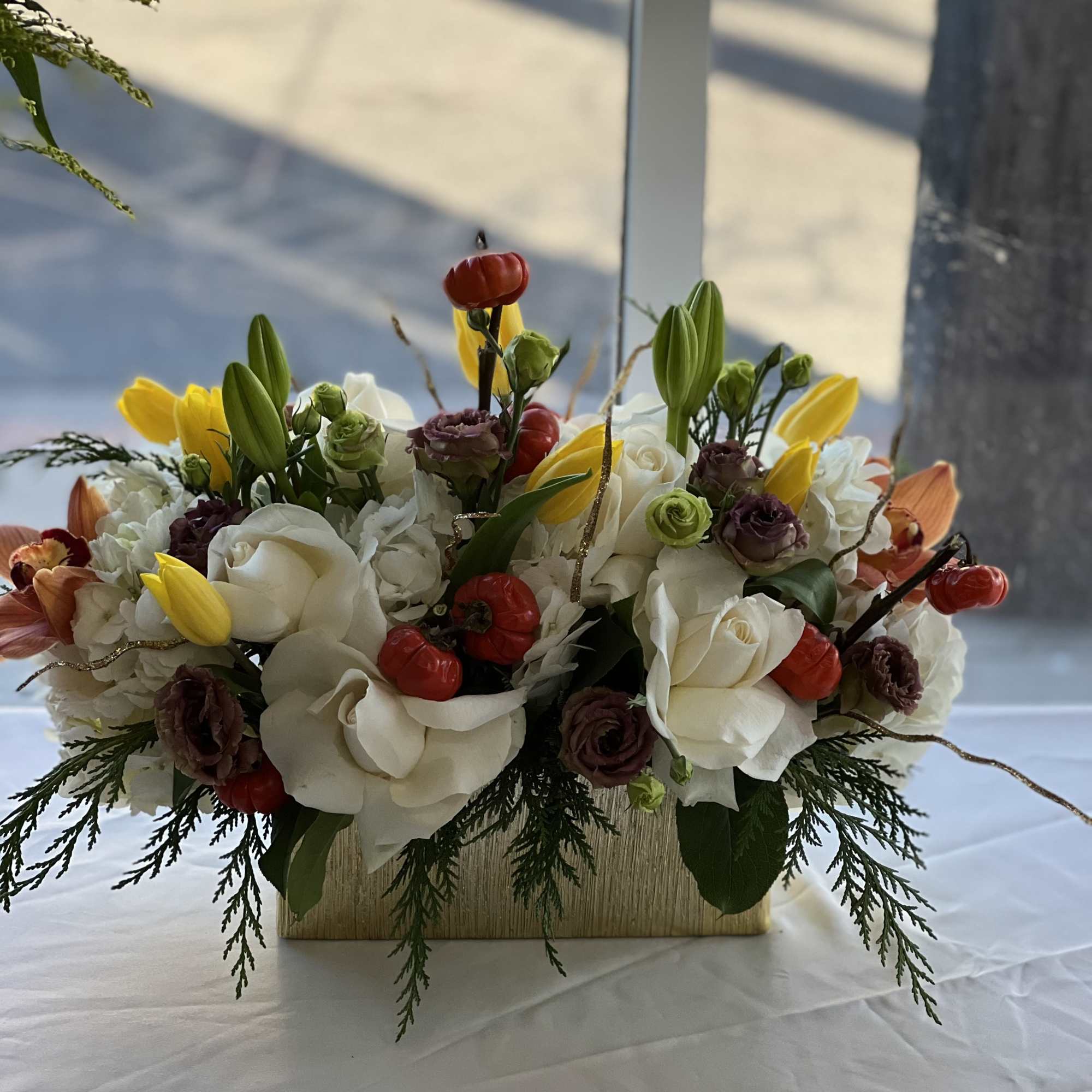White and yellow floral arrangement in a rectangular vase