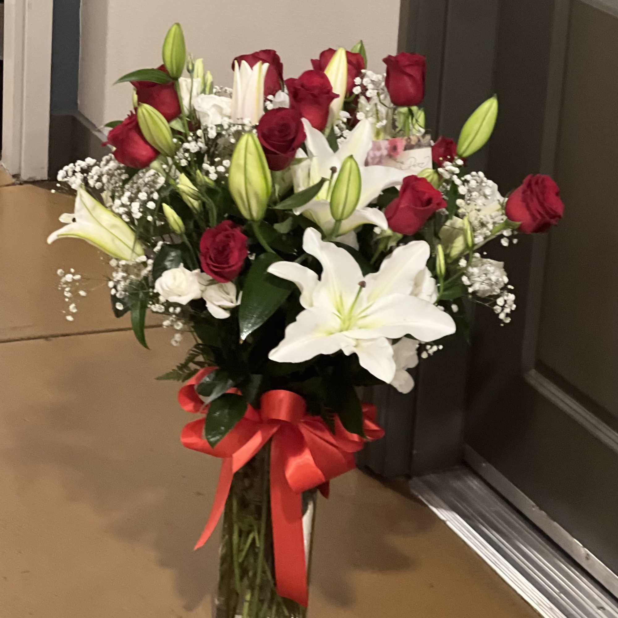 Bouquet of red roses and white lilies in a glass vase with a red ribbon, photo 2 of 4