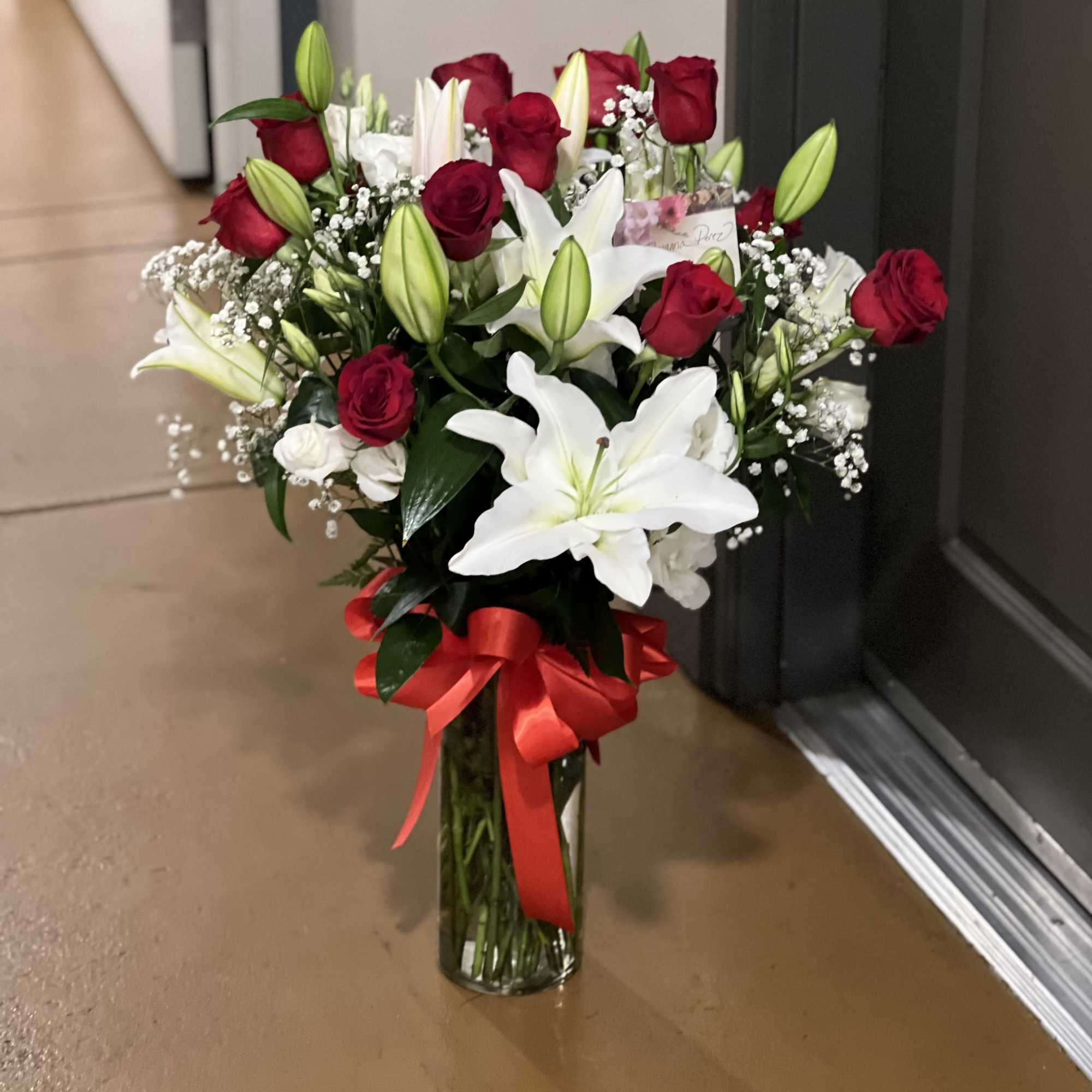 Bouquet of red roses and white lilies in a glass vase with a red ribbon, photo 3 of 4