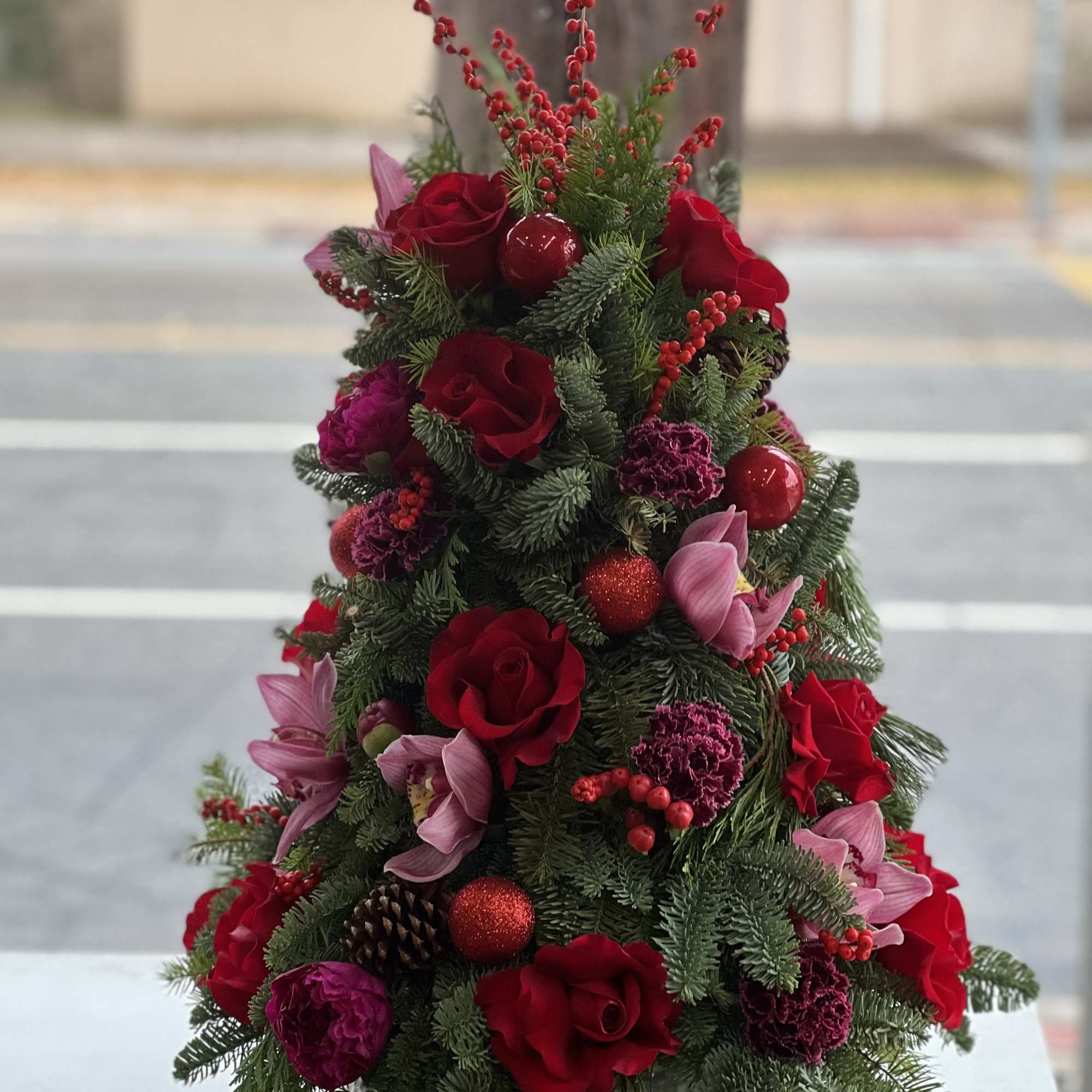 Christmas arrangement with red roses and pink flowers in a white vase