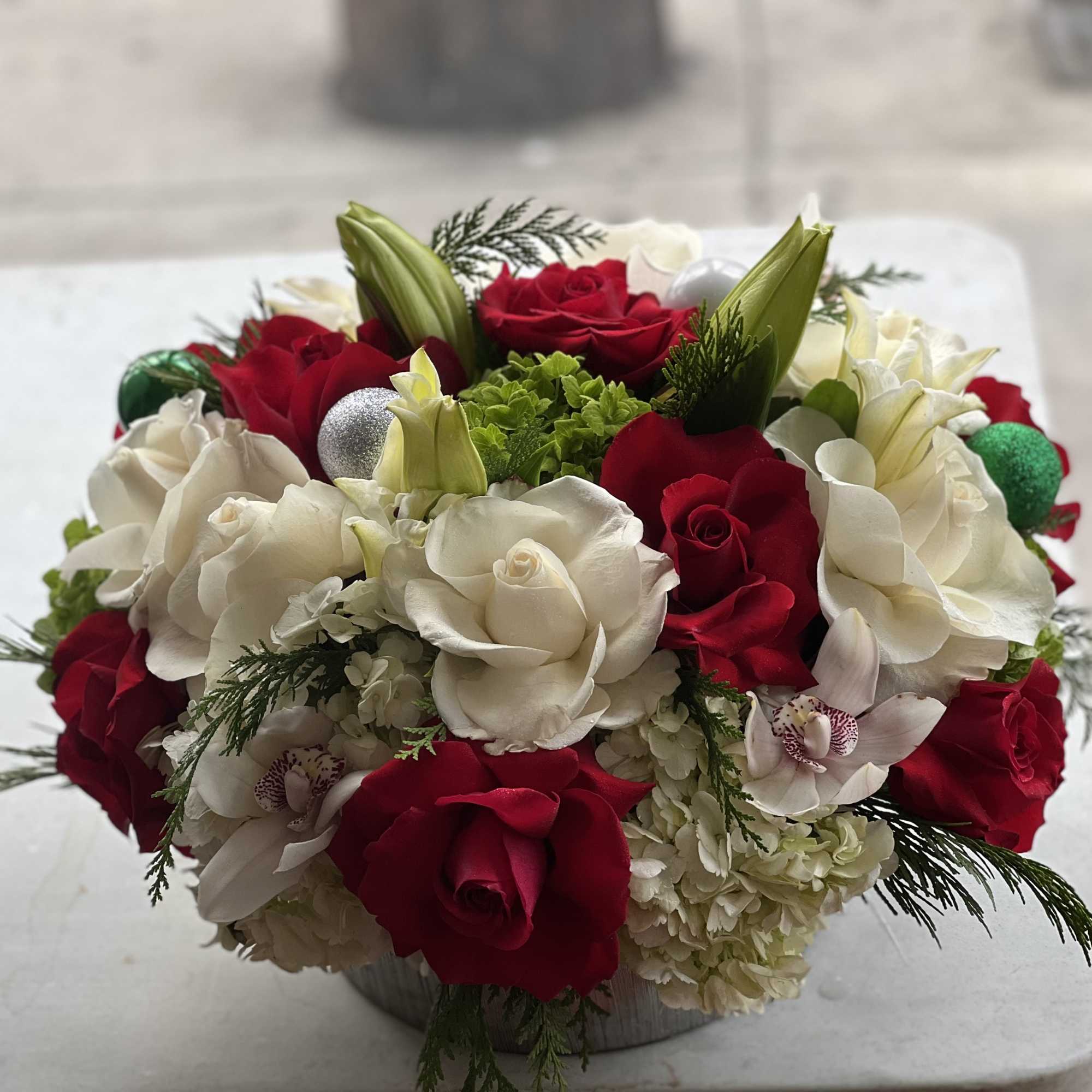 Red and white roses arranged in a low round container