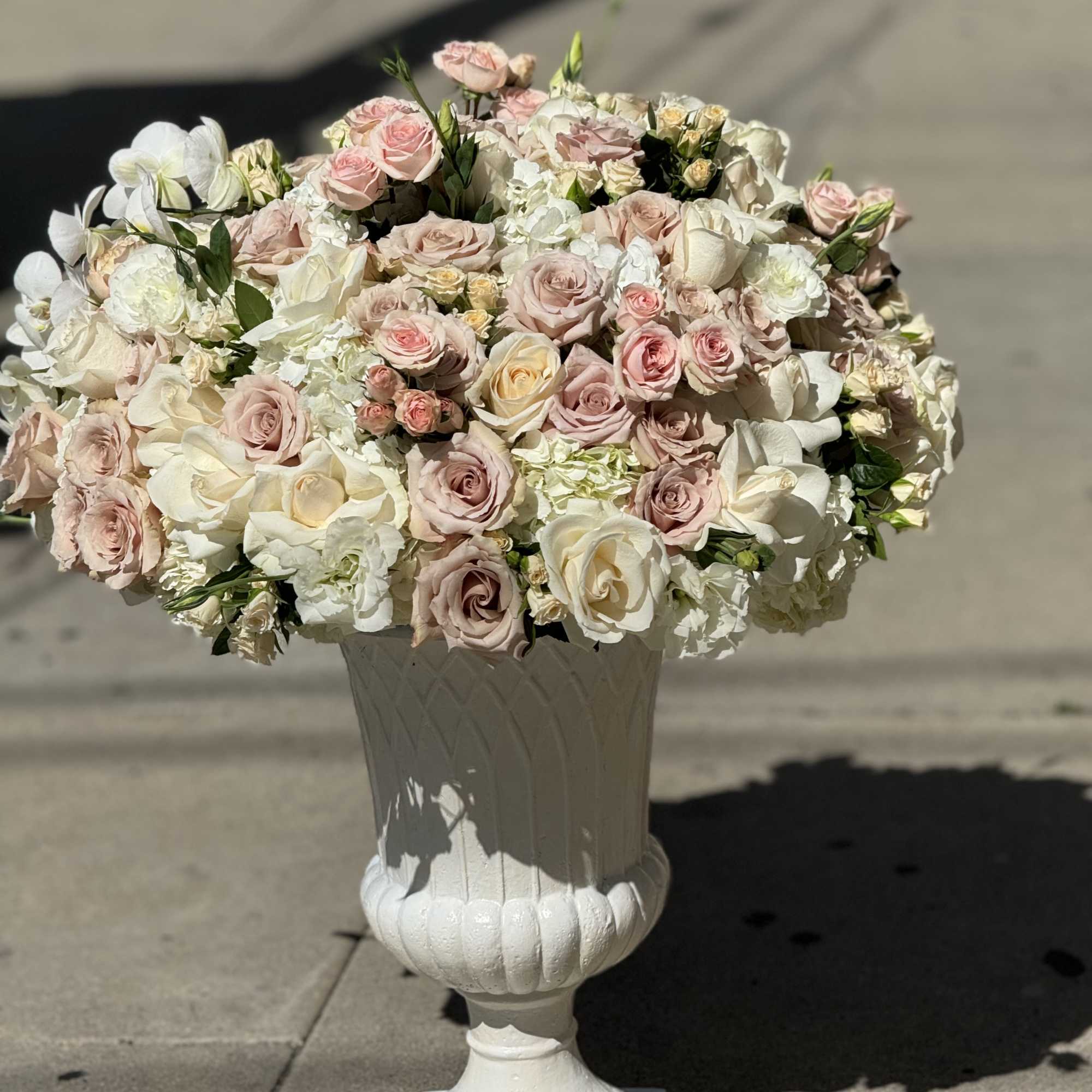 Large pastel rose arrangement in a white pedestal vase, photo 2 of 4