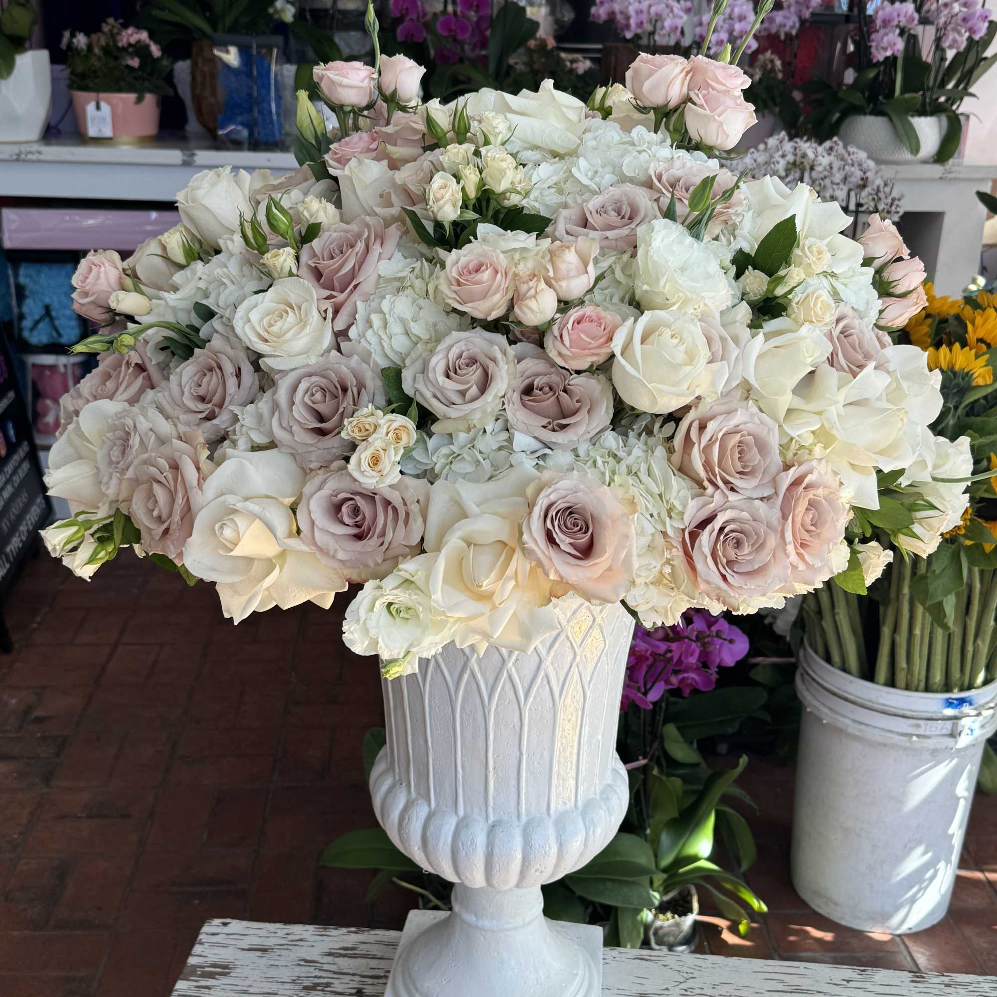 Large pastel rose arrangement in a white pedestal vase, photo 3 of 4