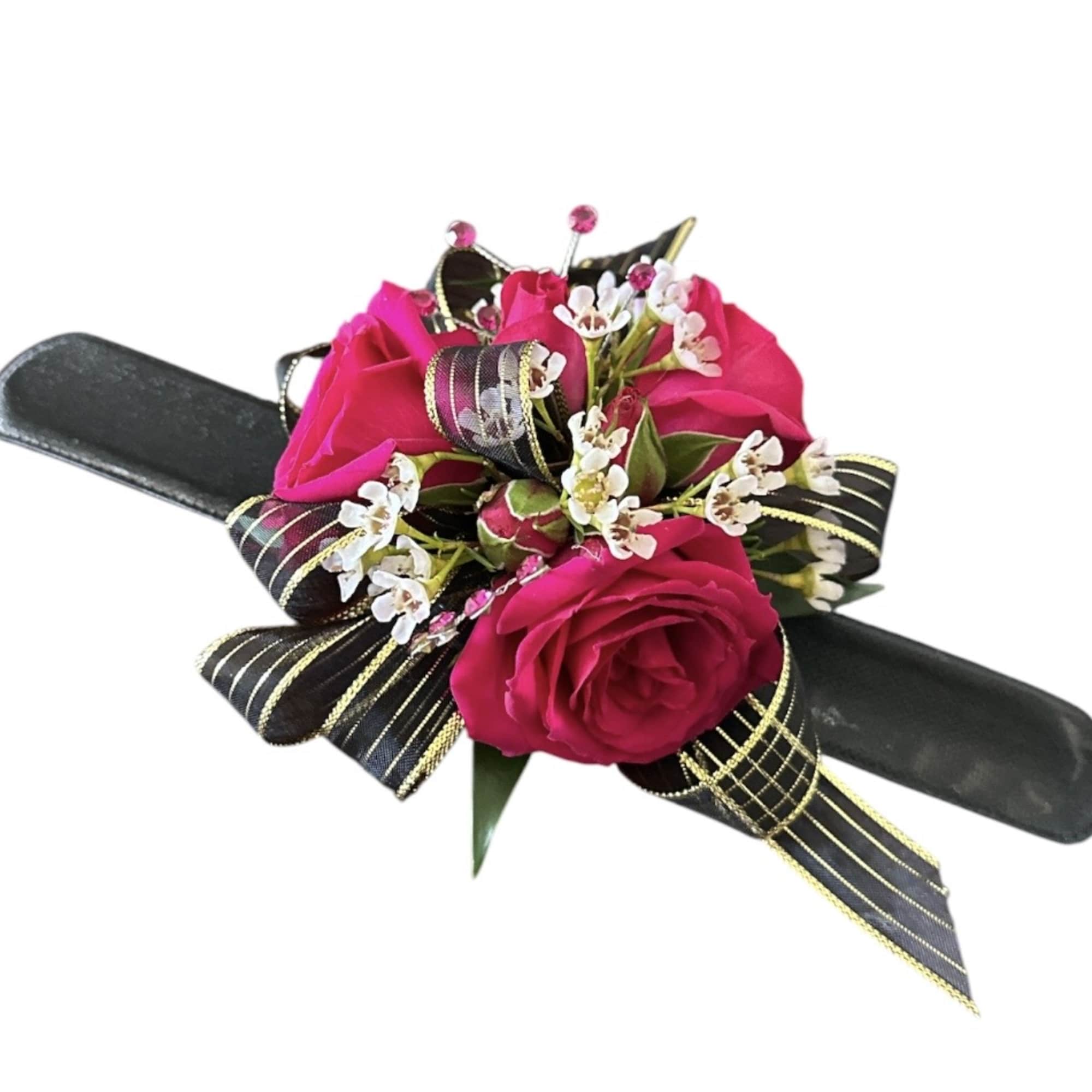 Pink rose corsage with white filler flowers on a black wristlet