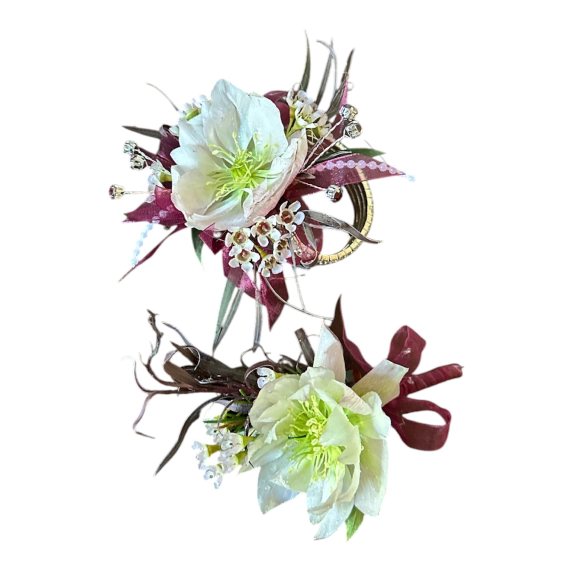 Two white floral wrist corsages with burgundy accents and ribbon on a white background