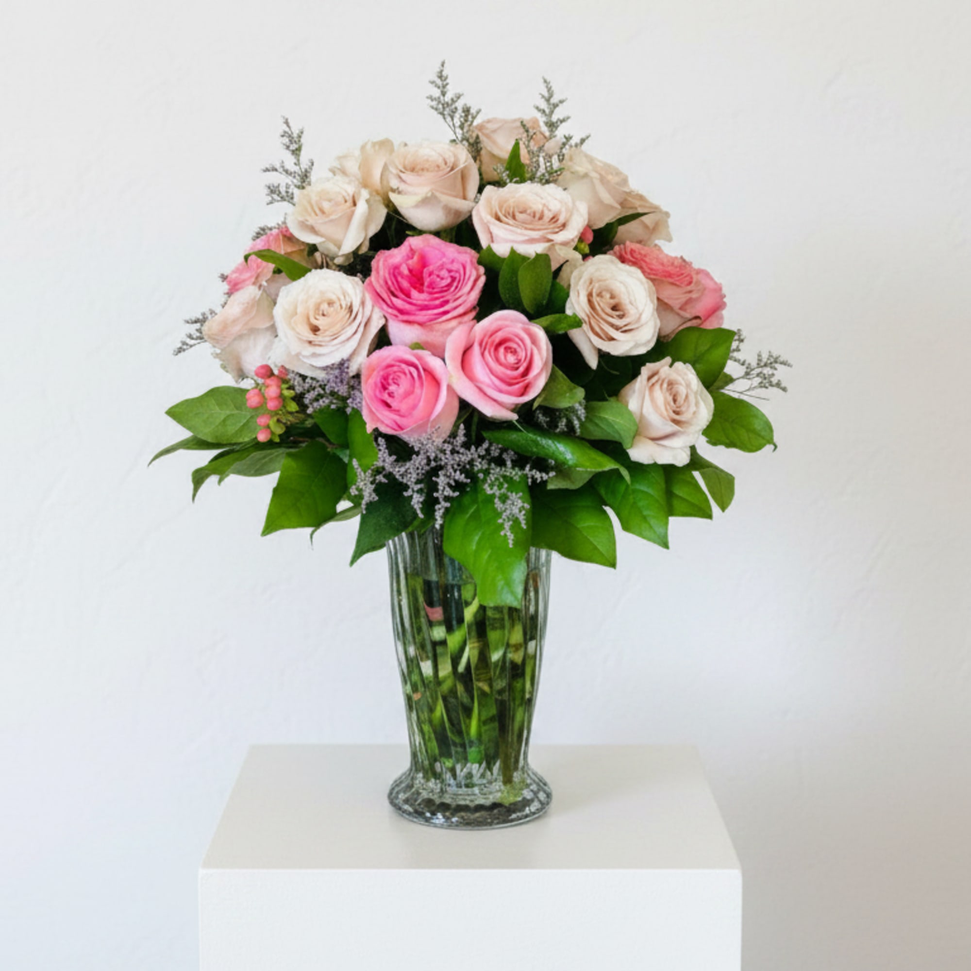 Pink and cream roses arranged in a clear glass vase