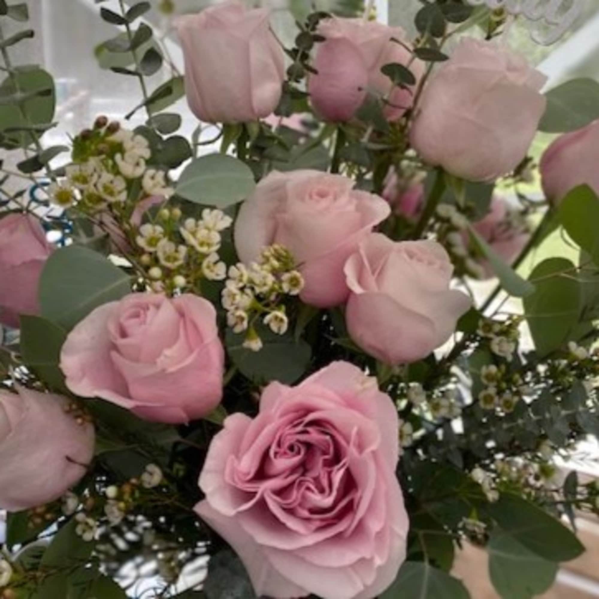 Arrangement of light pink roses with small white blossoms
