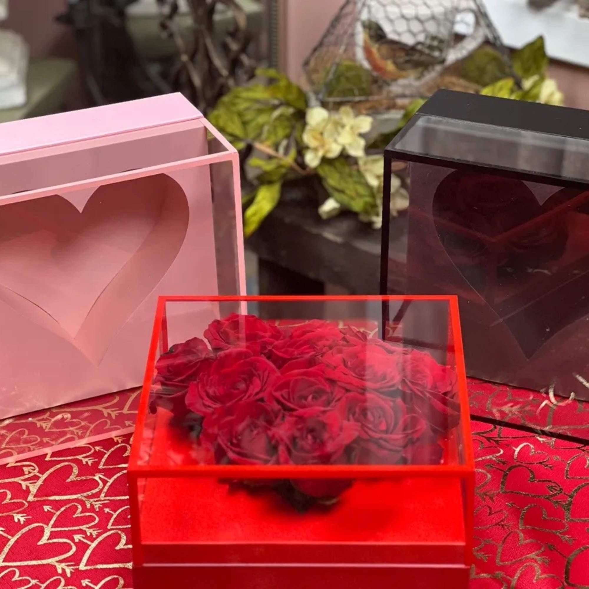 Heart-shaped rose arrangements in clear gift boxes