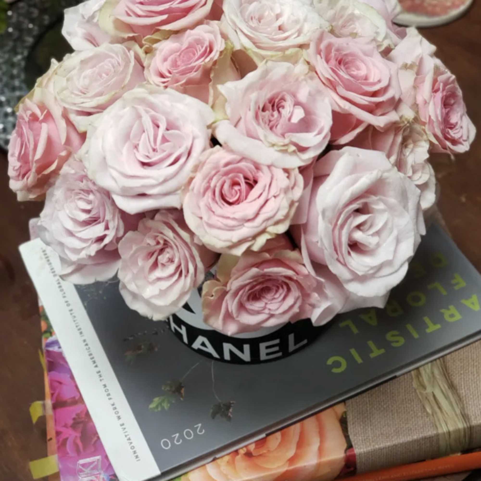 Bouquet of pale pink roses in a black hat box