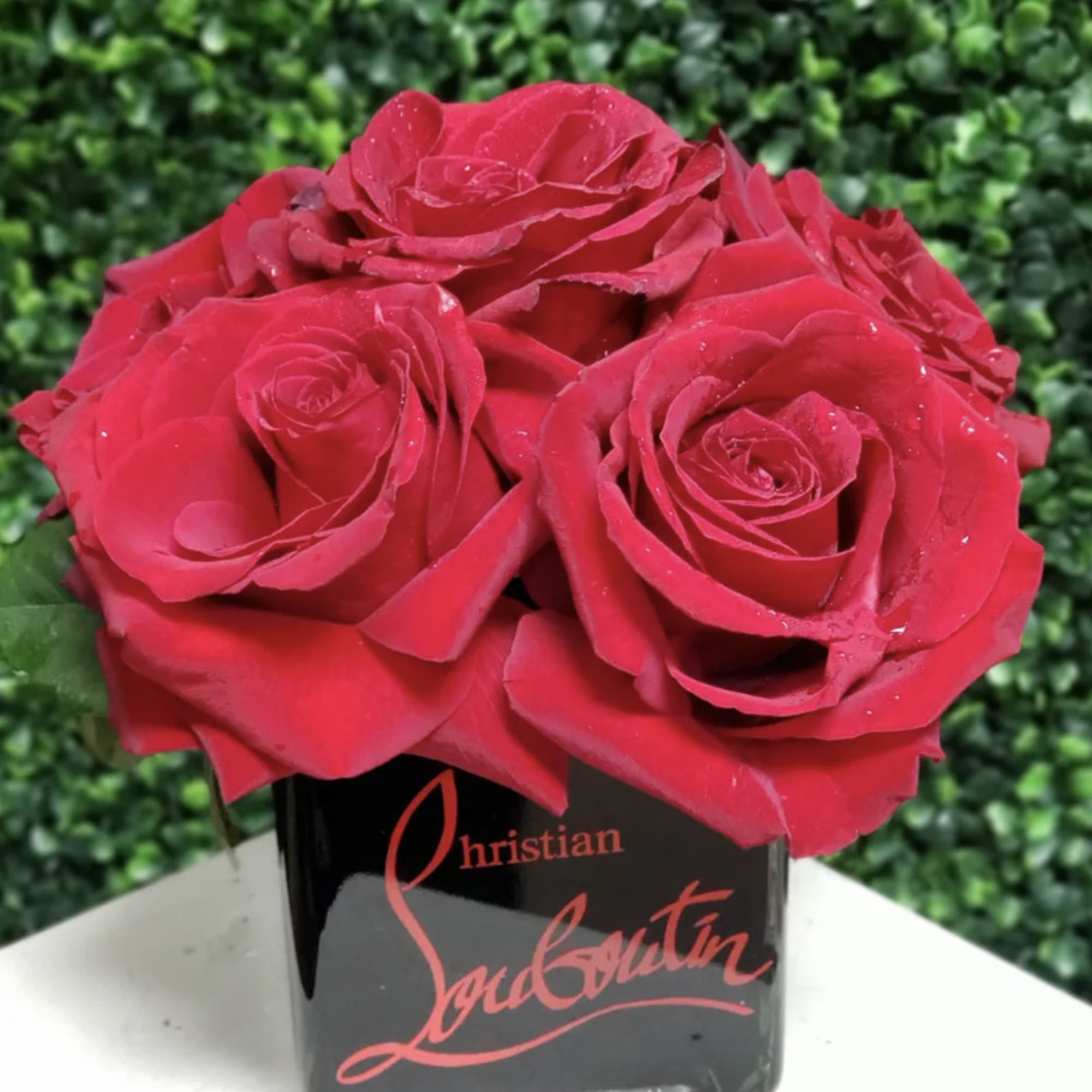 Red roses arranged in a black square vase