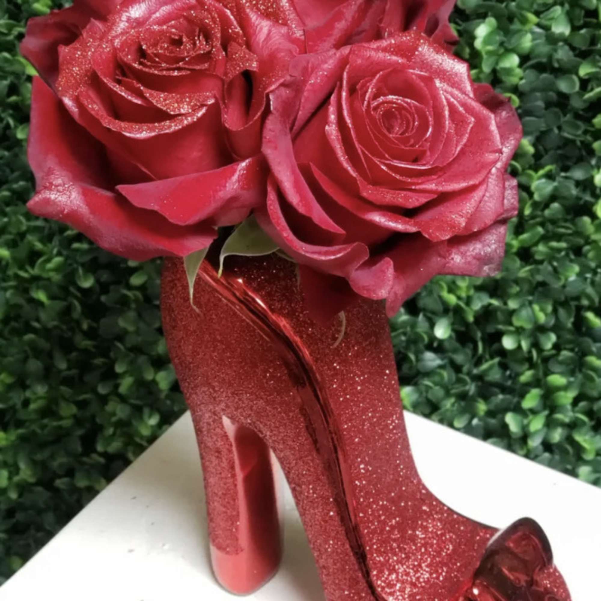 Red roses arranged in a glittery high-heel shoe vase