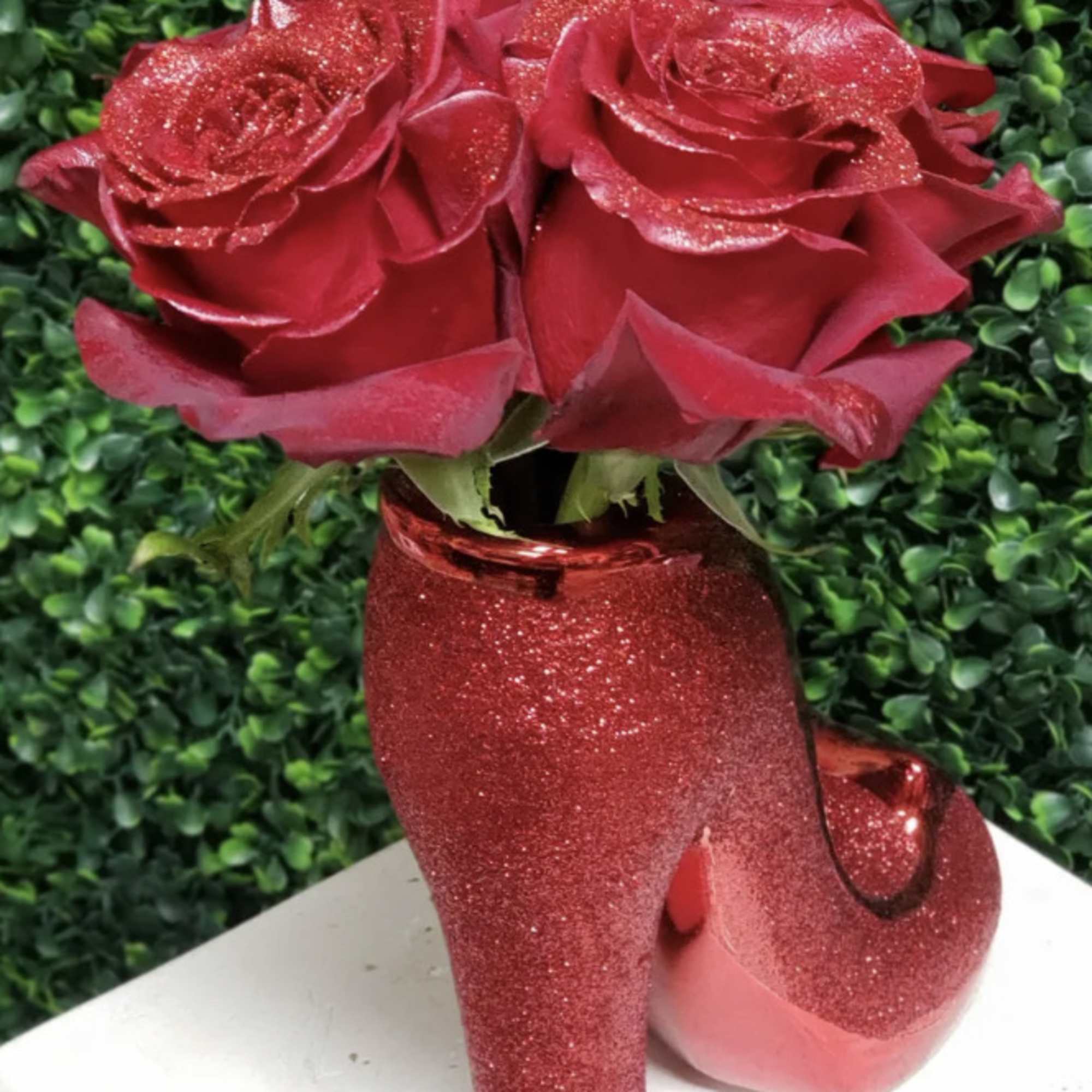 Red roses in a glittery red high-heel vase