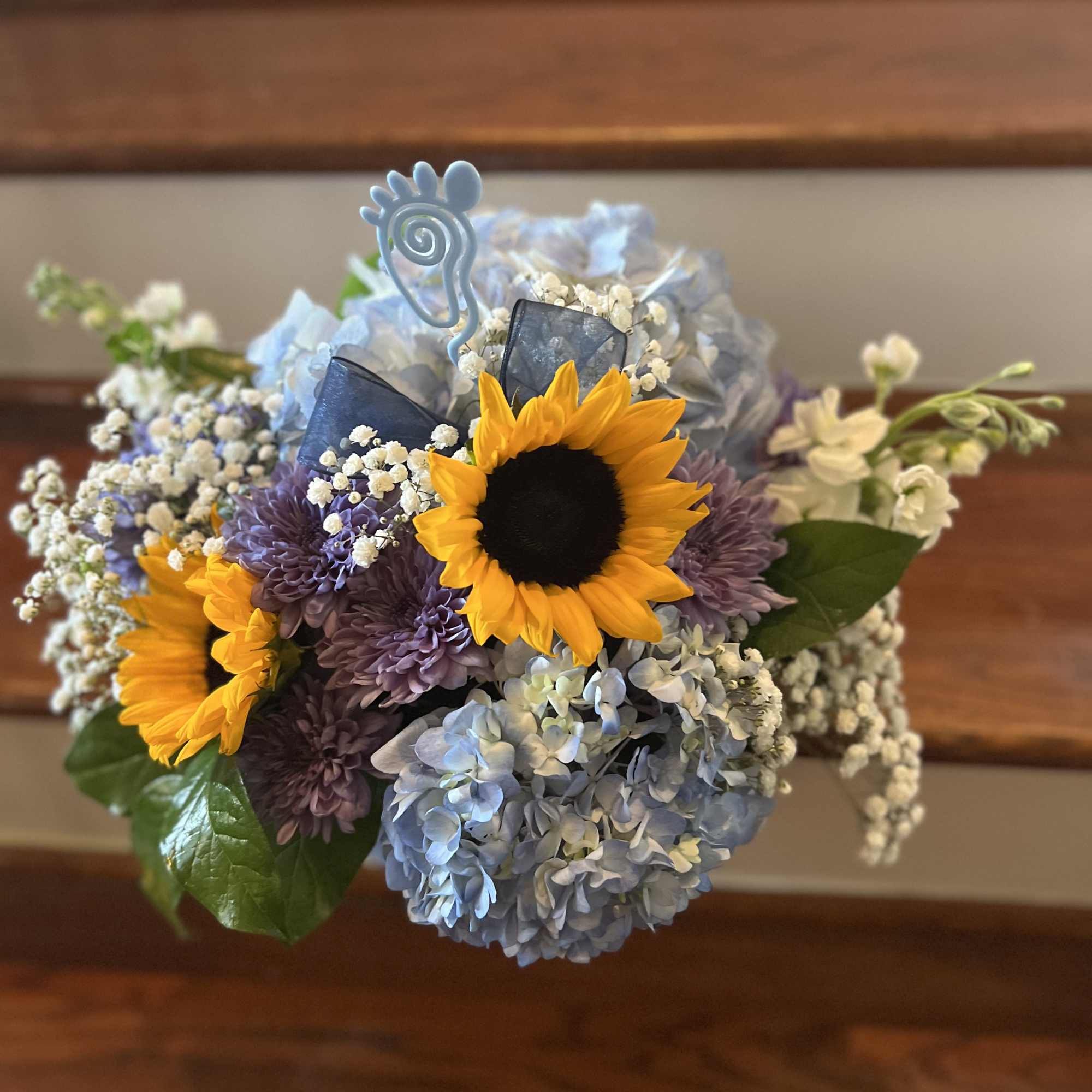 Bouquet of sunflowers, blue hydrangeas, and purple mums with baby’s breath