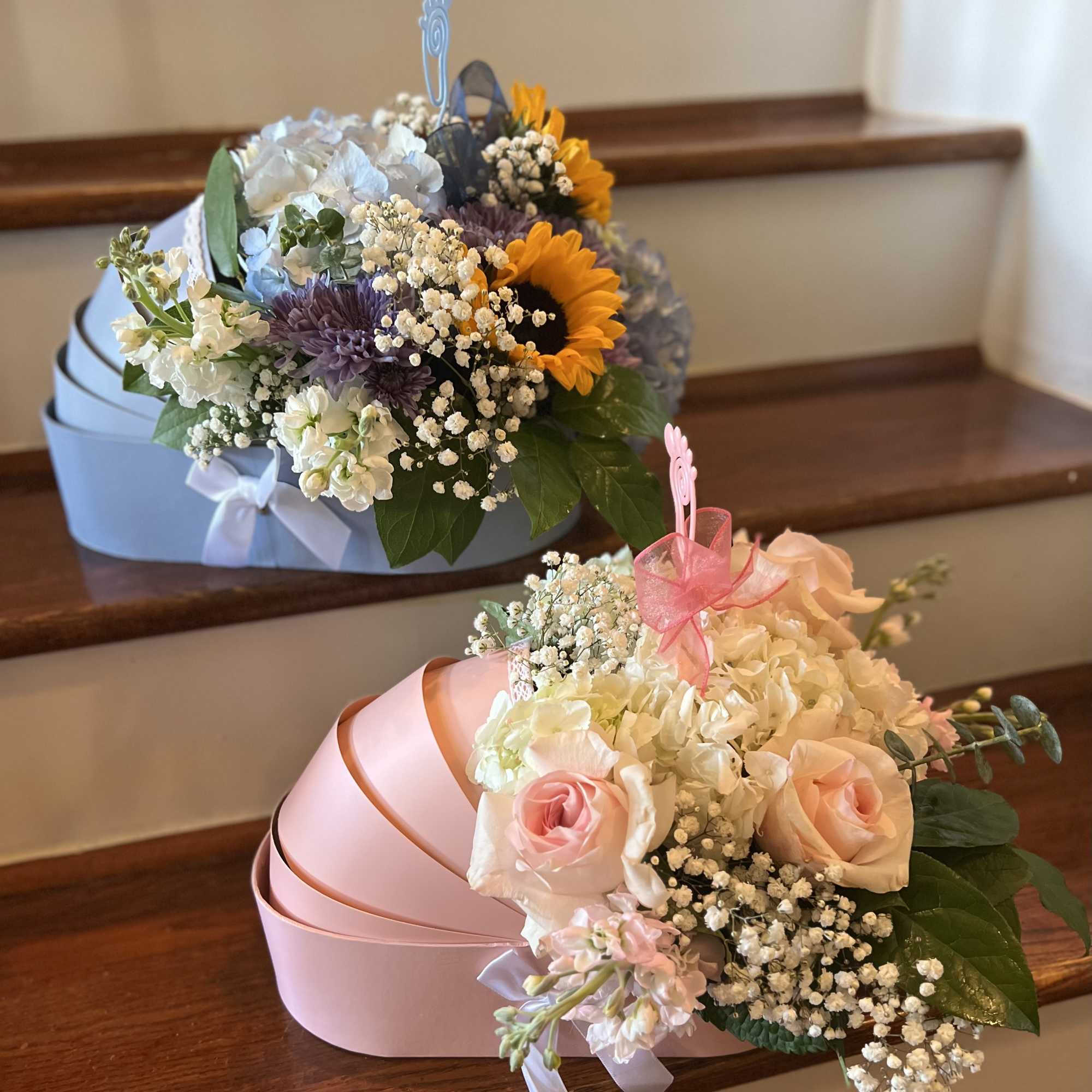 Two heart-shaped flower boxes with mixed blooms, including roses and sunflowers.