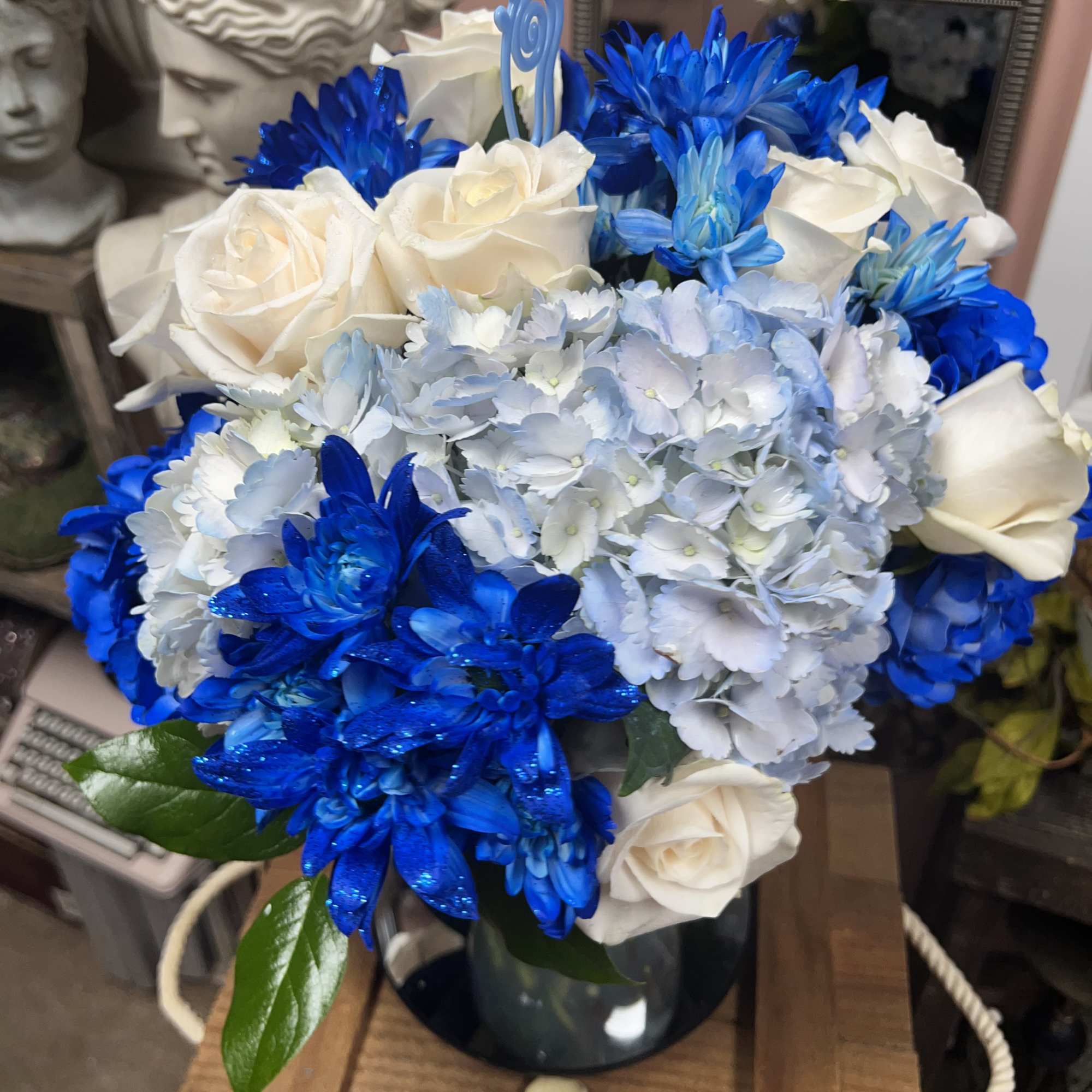 Blue and white bouquet of roses and hydrangeas in a vase
