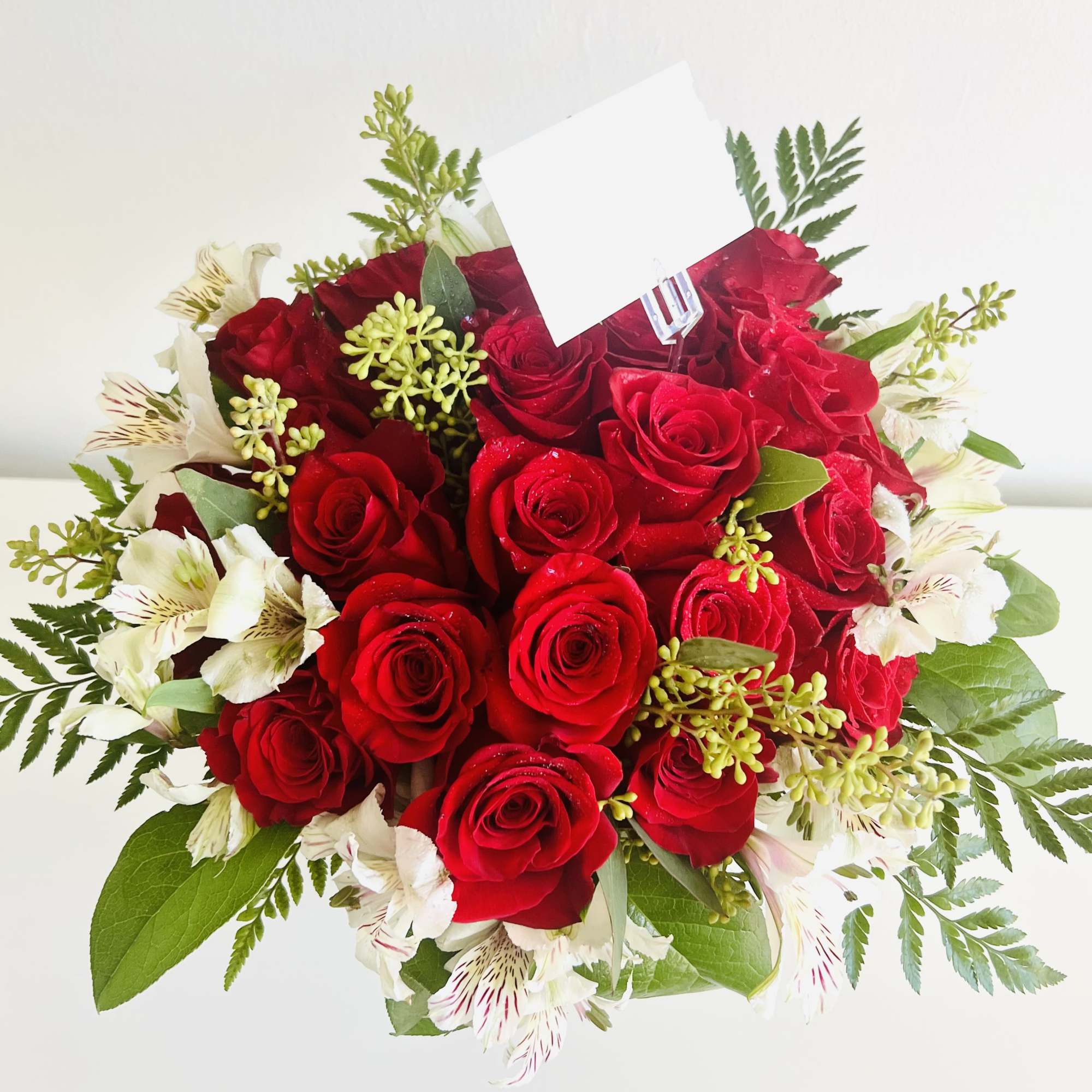 A stunning bouquet of 25 premium roses surrounded by lush seasonal foliage, photo 2 of 2