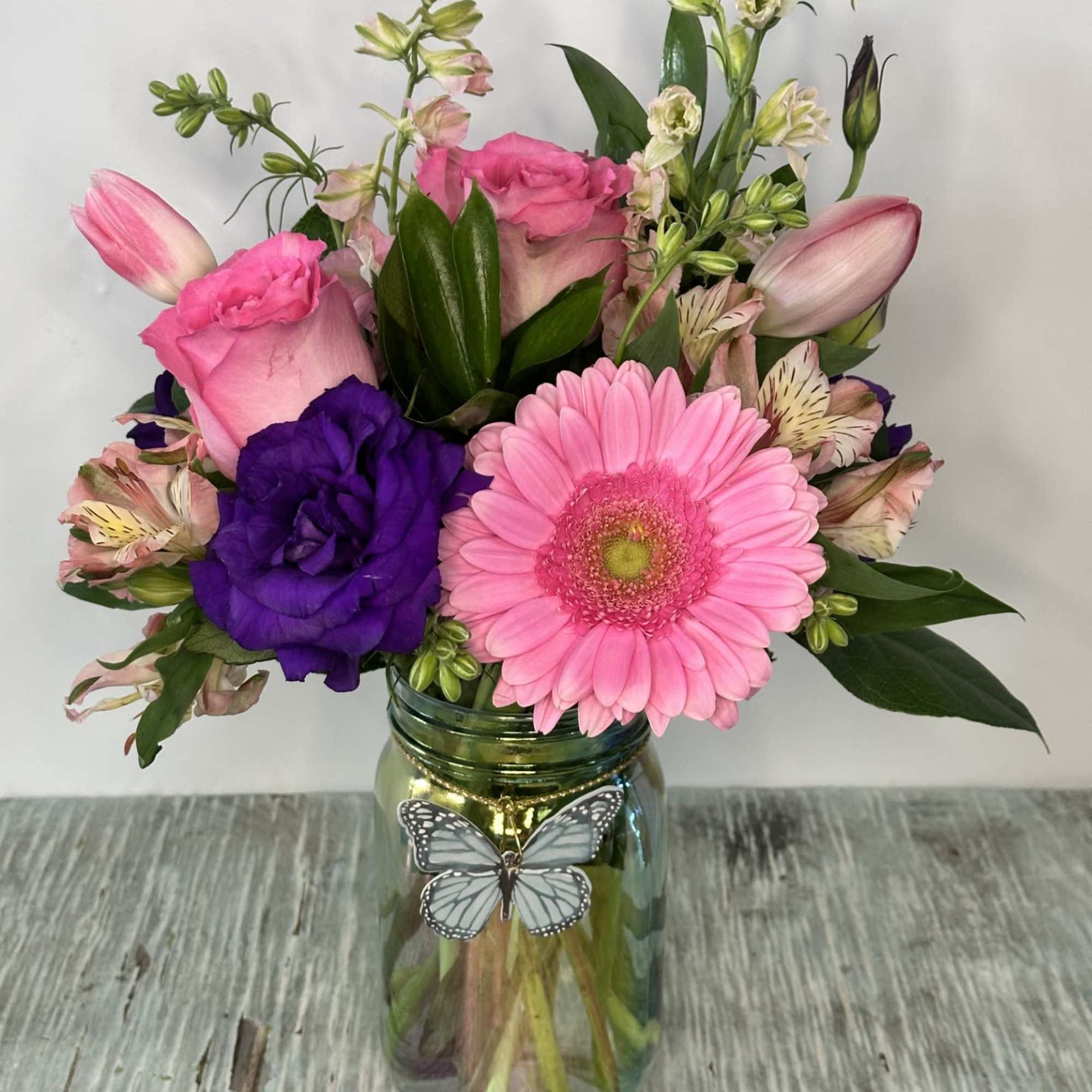 Pink and purple mixed bouquet in a glass jar vase