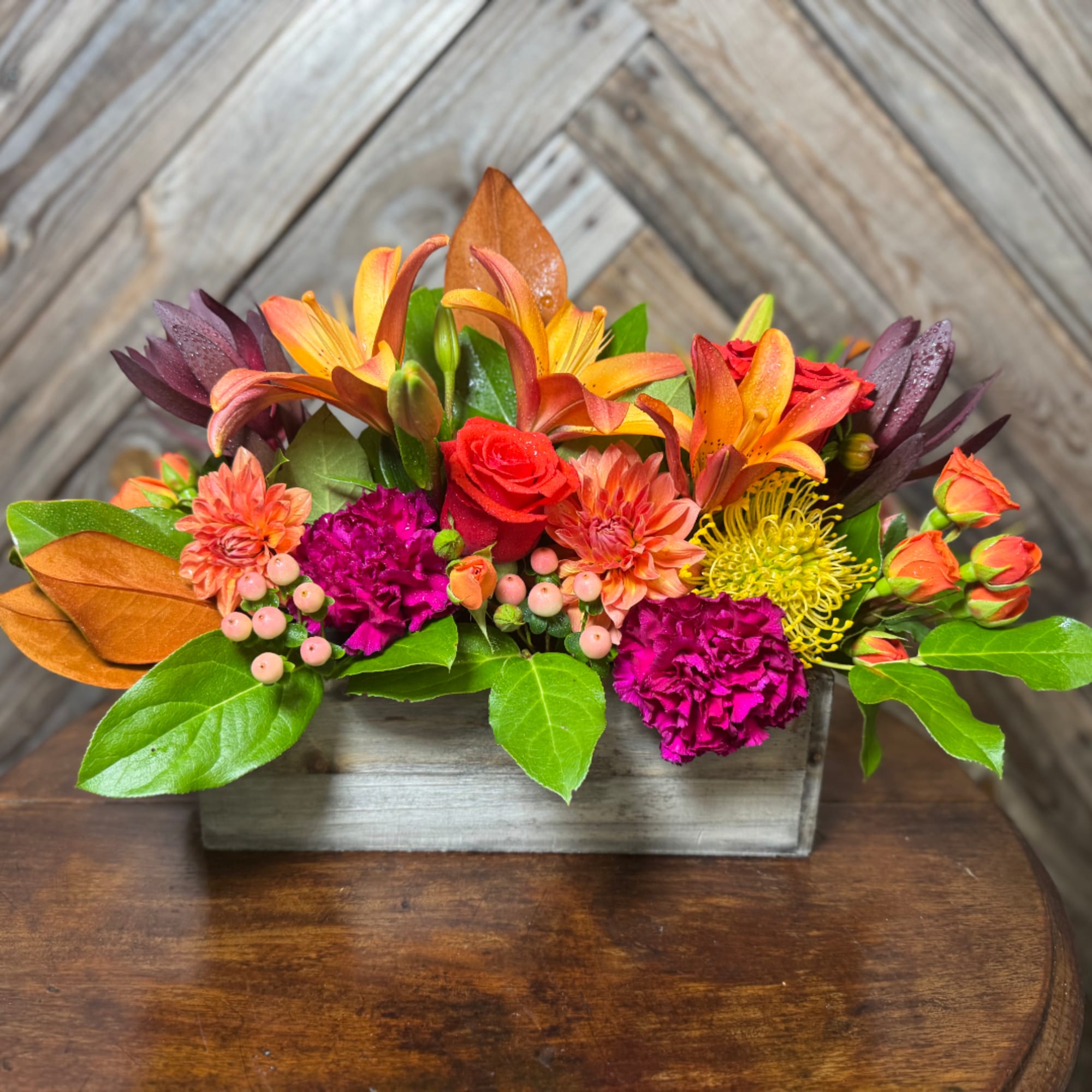 Colorful mixed flower arrangement in a rectangular wooden container