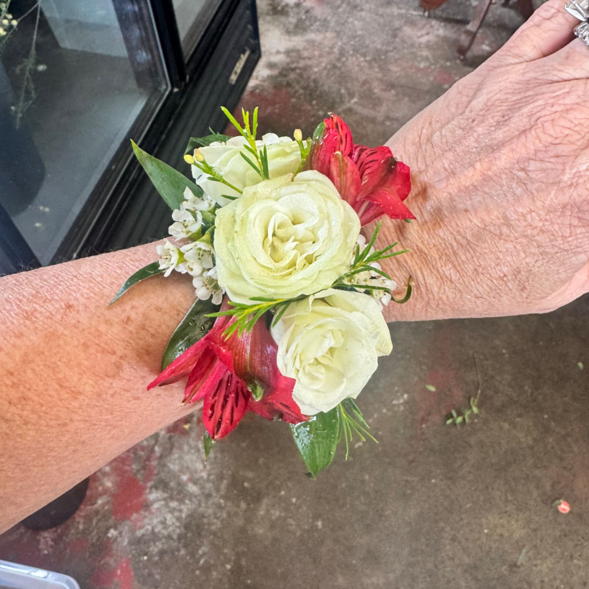 Small wrist corsage with white roses and red flowers