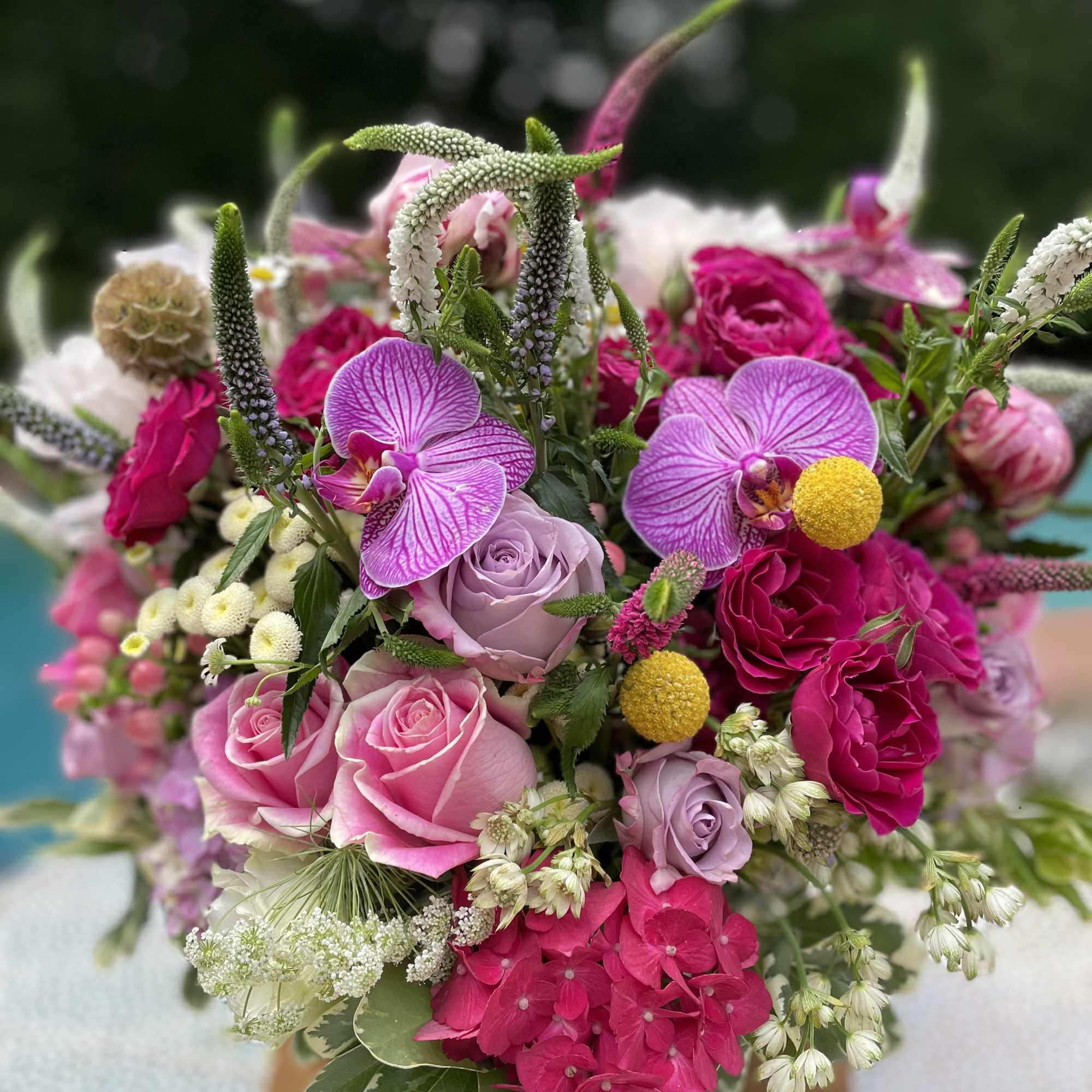 Bouquet of pink and lavender roses with orchids and mixed blooms