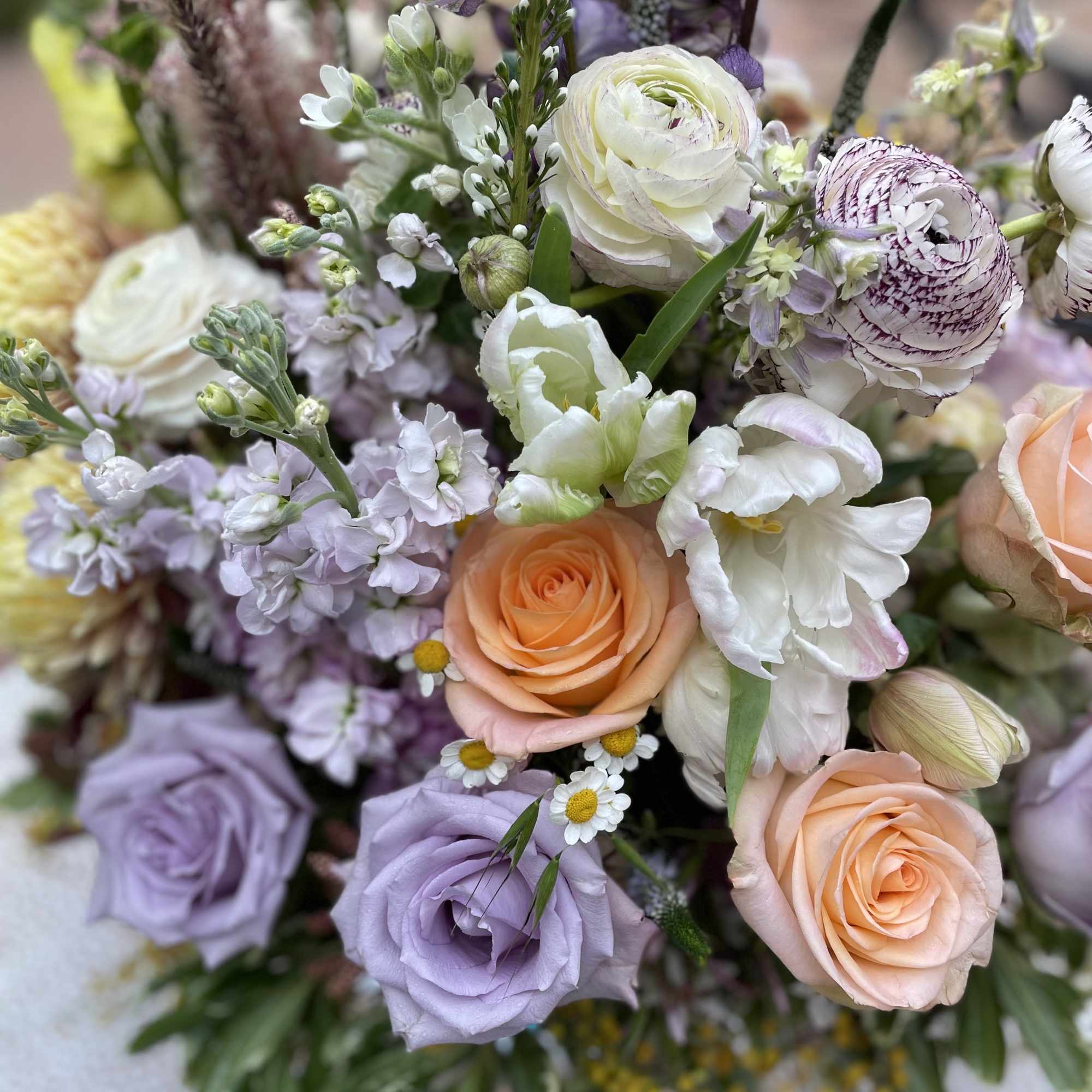 Bouquet of peach, lavender, and white flowers with roses and ranunculus
