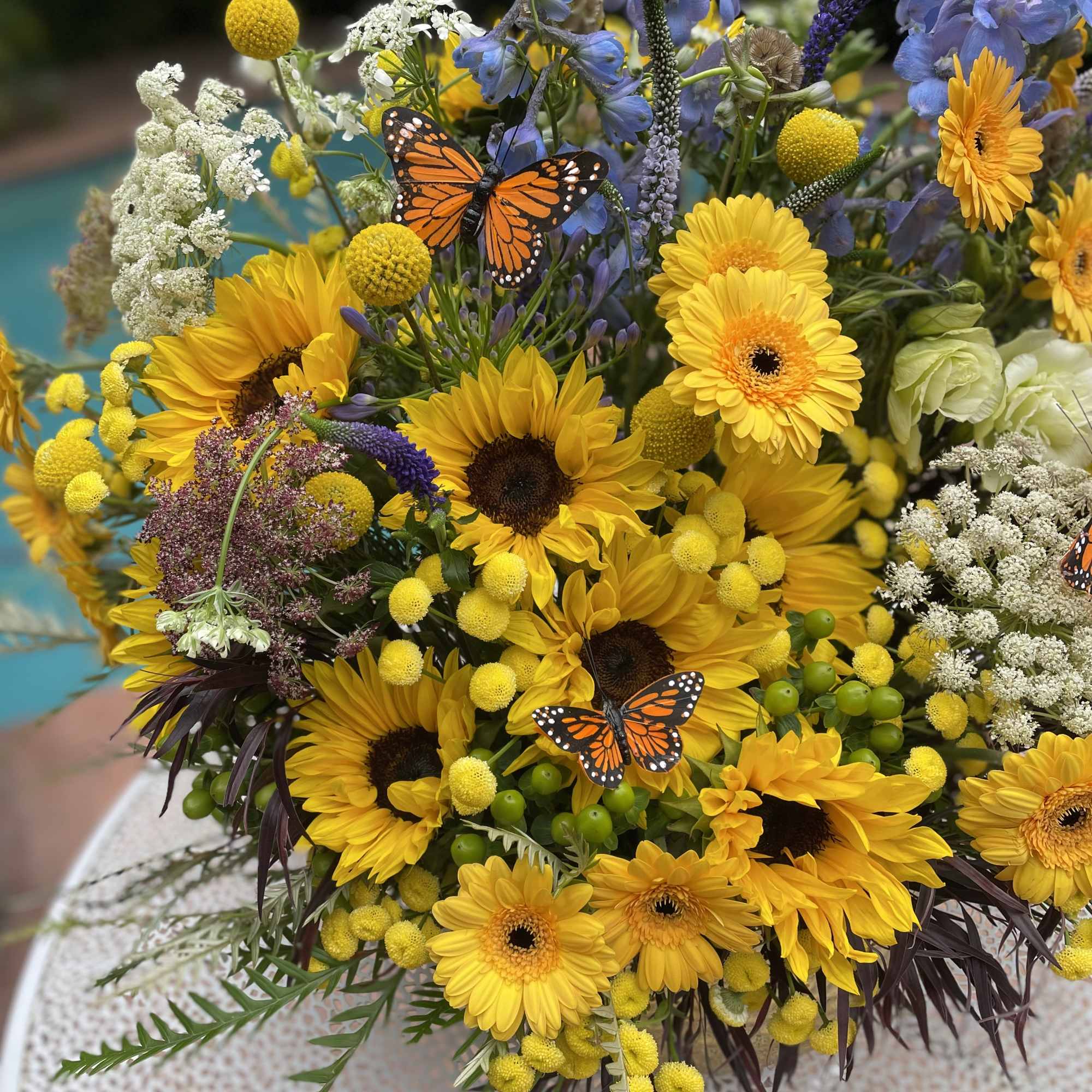 Mixed bouquet with sunflowers, yellow gerberas, and blue delphinium