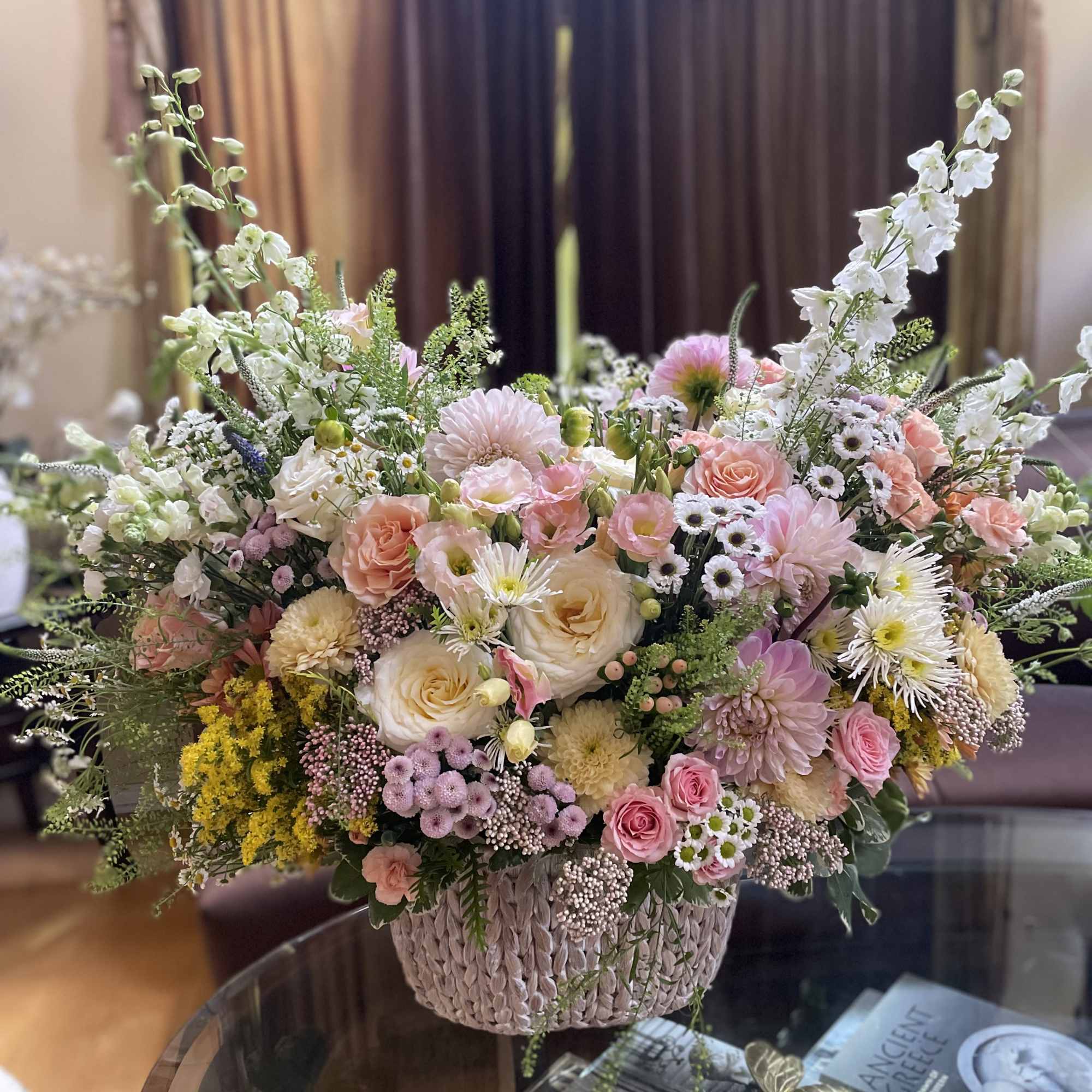 Large pastel flower arrangement in a woven basket