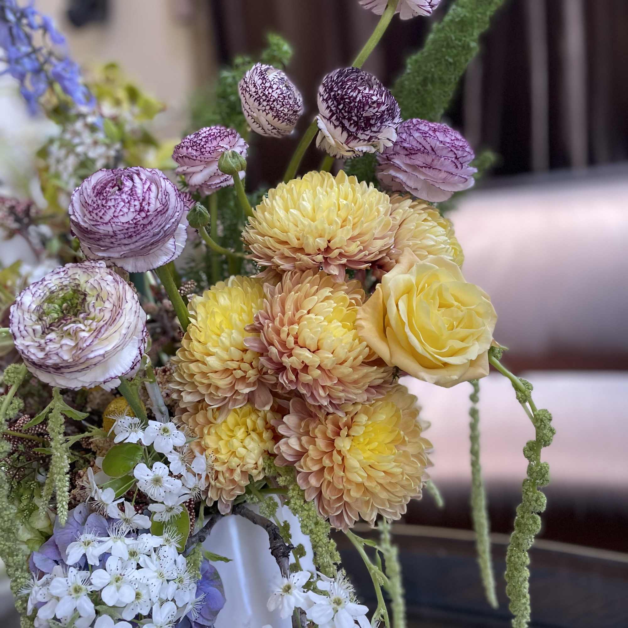 Bouquet of yellow and lavender flowers with white blossoms in a vase