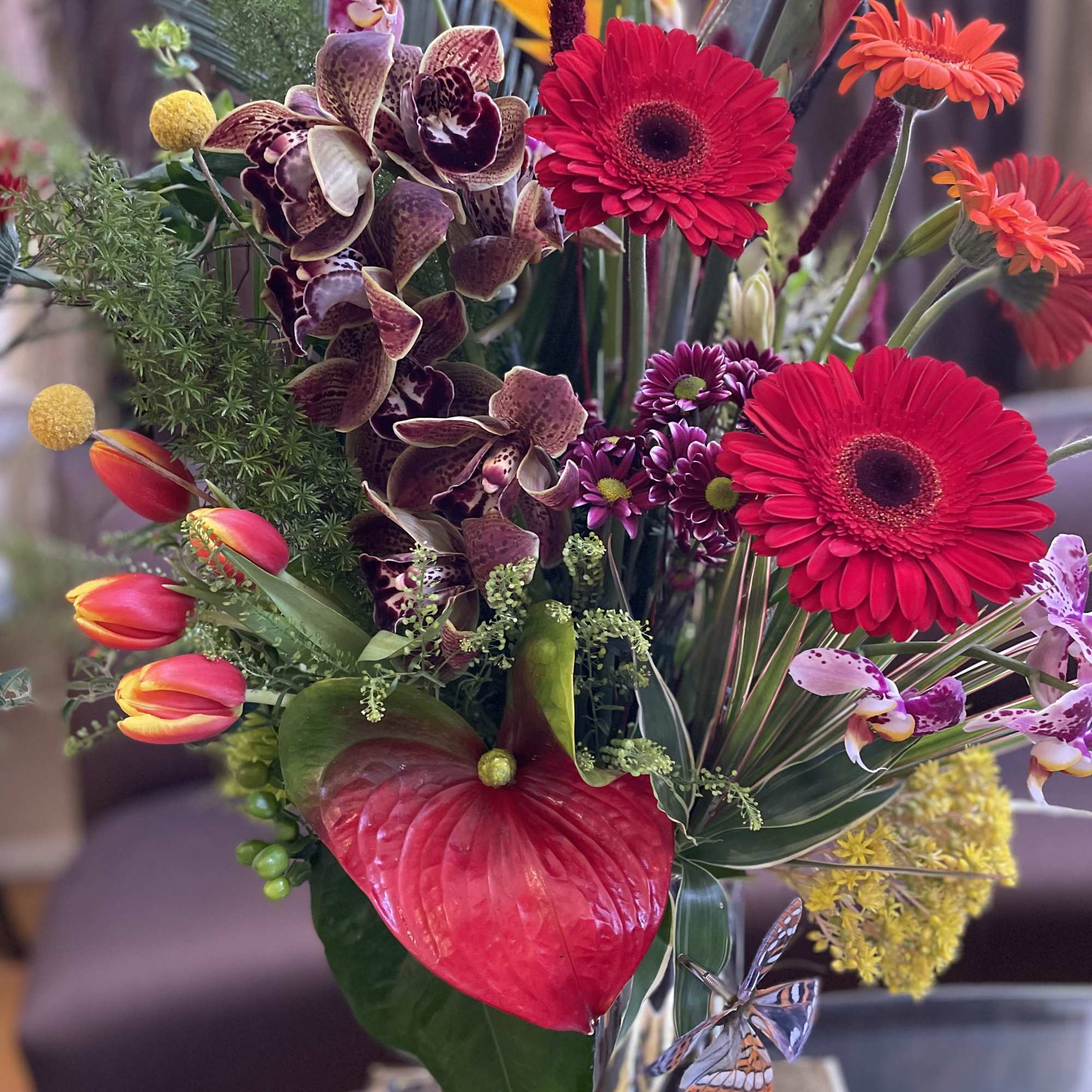 Mixed tropical bouquet with red gerberas, orchids, and anthurium