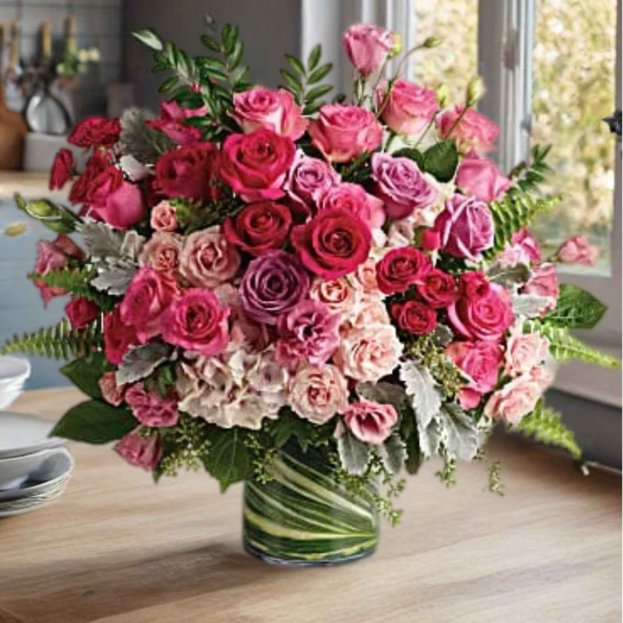 Pink and red roses arranged in a glass vase