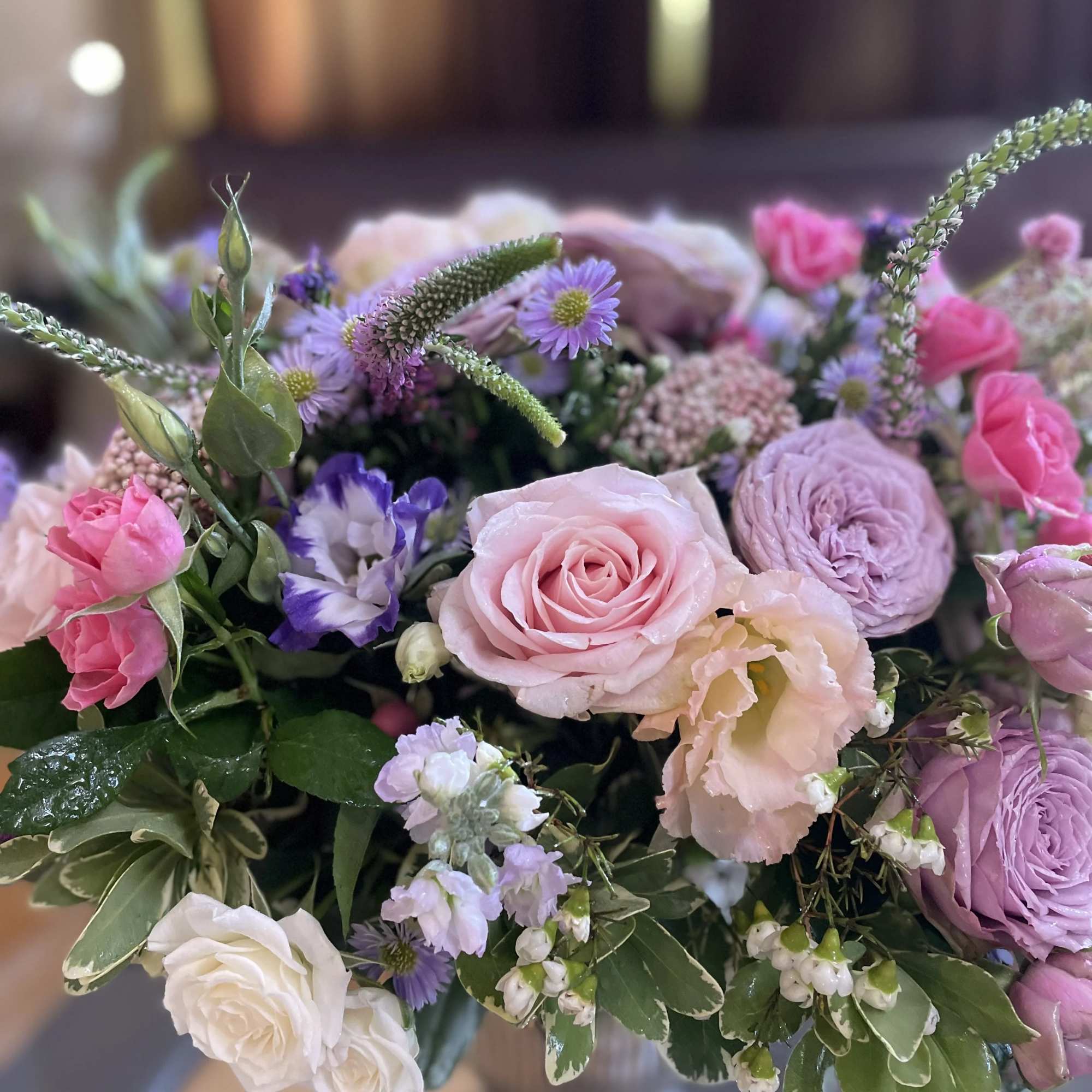 Bouquet of pink, lavender, and white flowers with roses and ranunculus