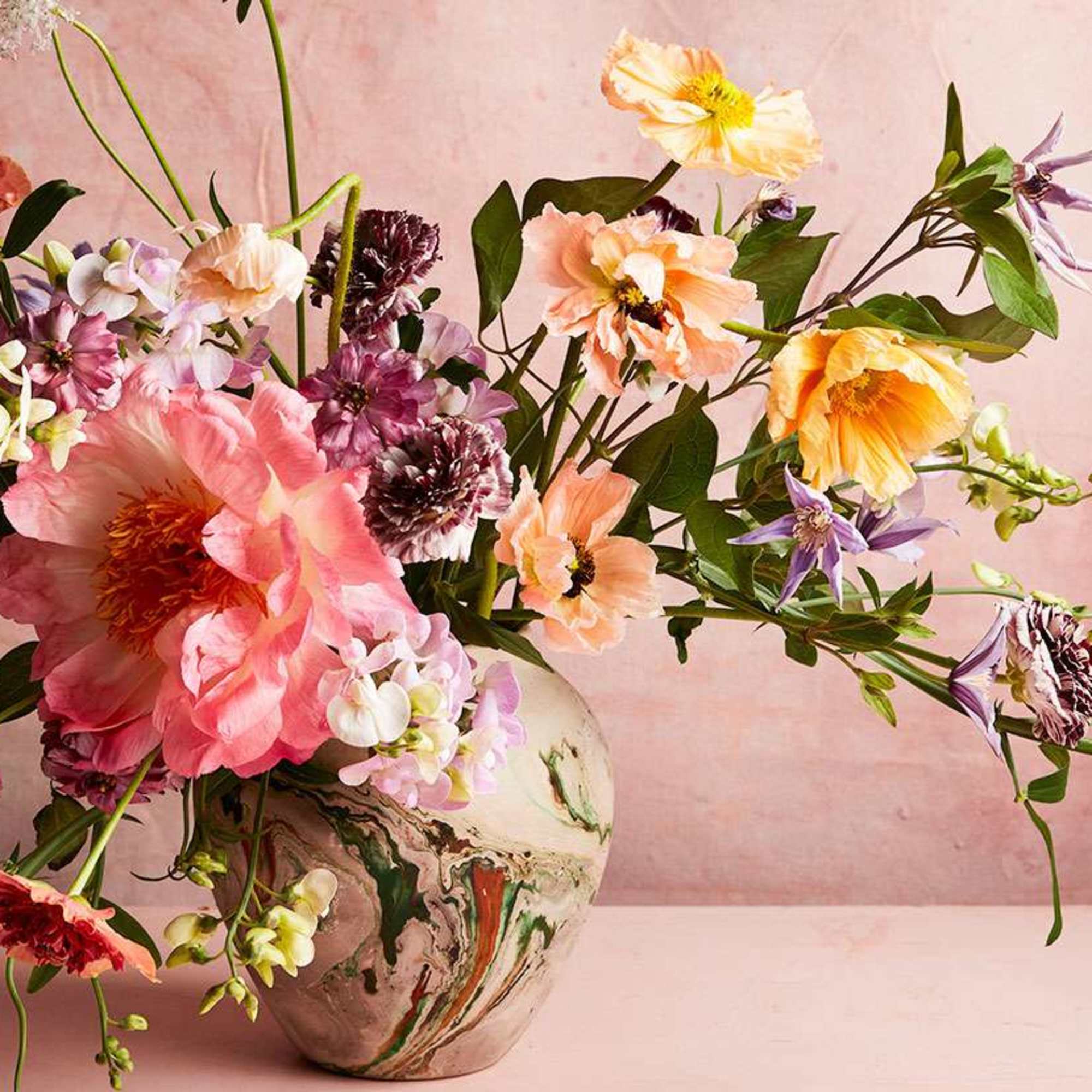 Loose bouquet of pink, peach, and purple flowers in a ceramic vase