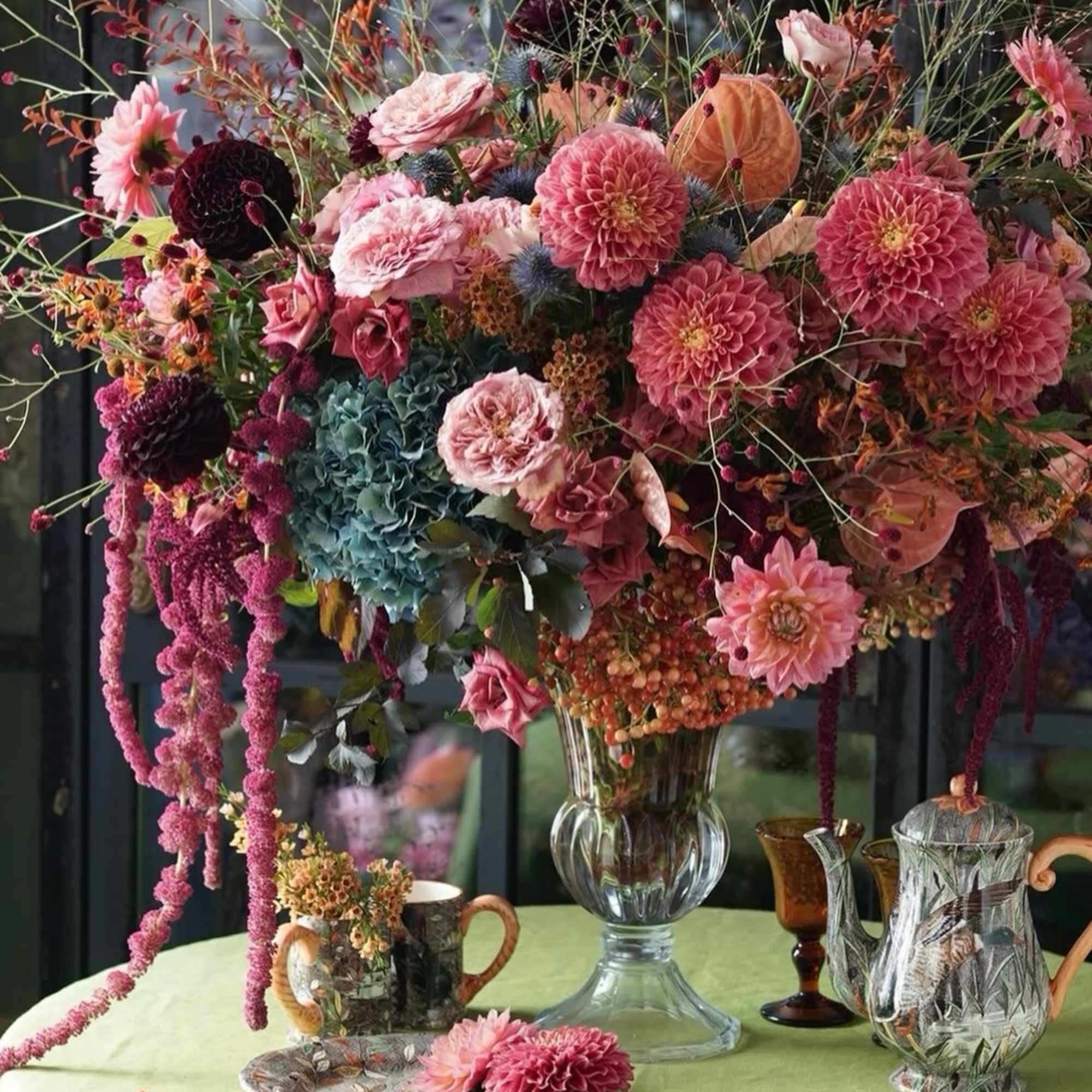 Large mixed floral arrangement in a clear glass vase on a table